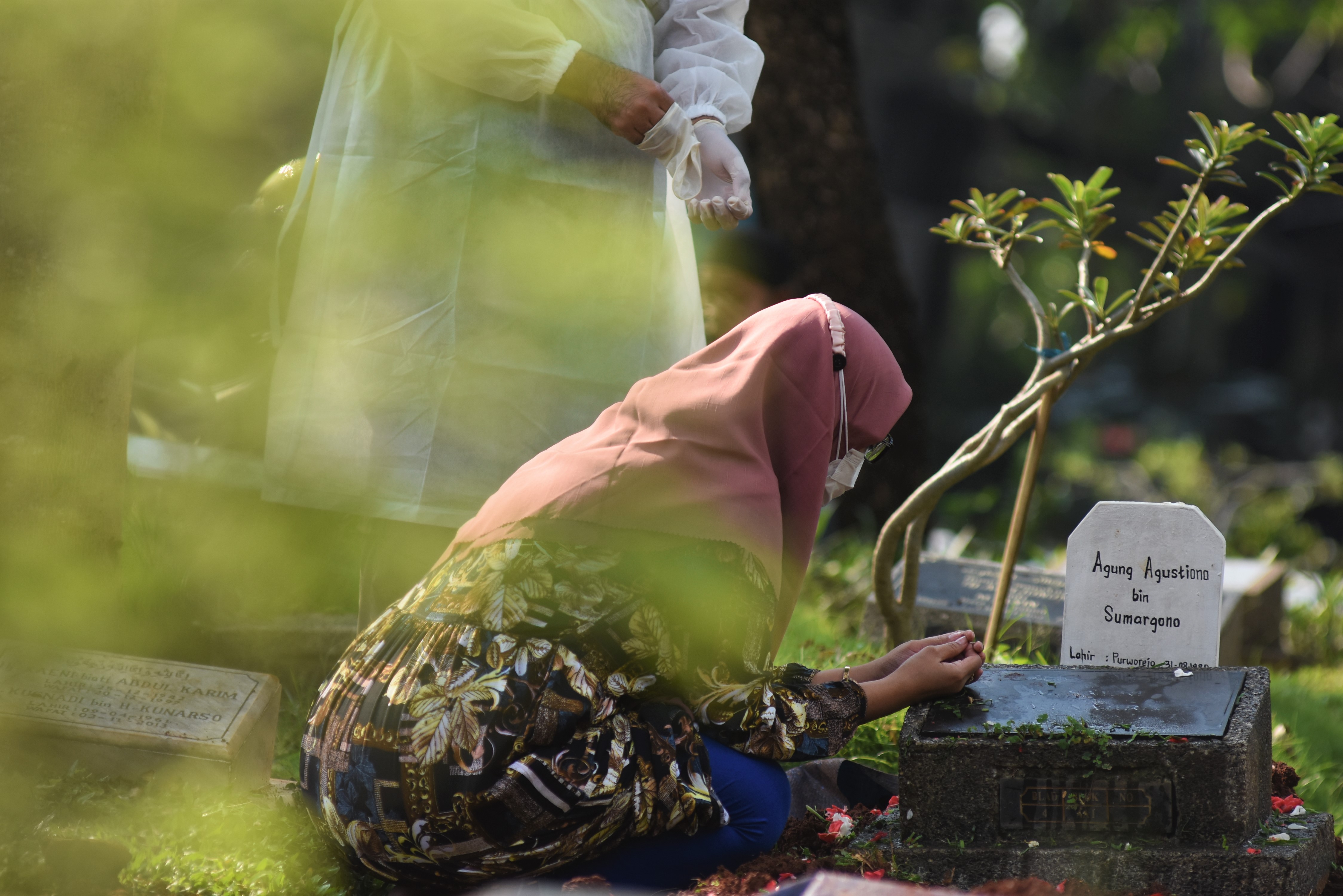 Keluarga berdoa di pusara jenazah teridentifikasi COVID-19 usai dimakamkan di TPU Karet Pasar Baru Barat, Jakarta