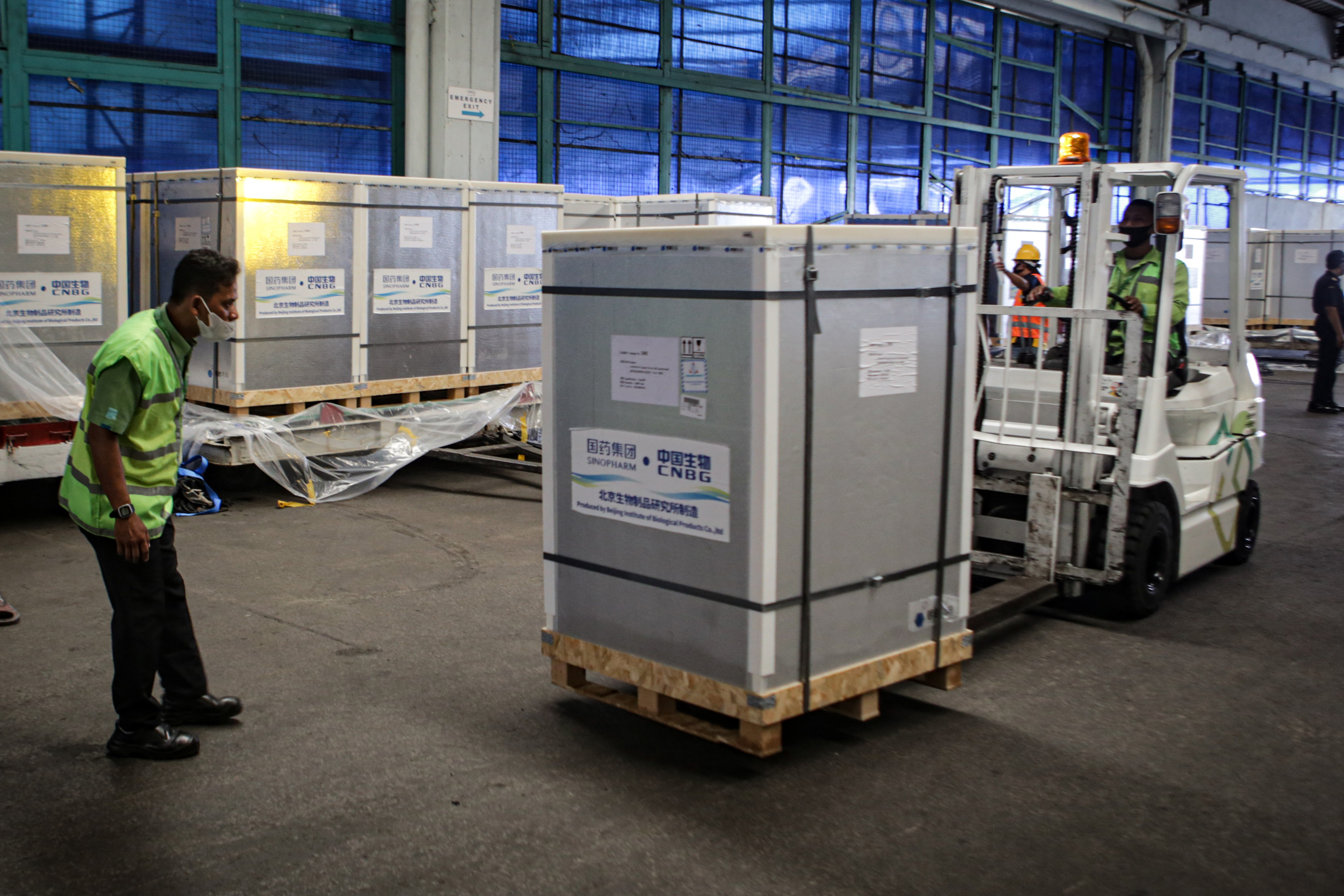 Pekerja membongkar kontainer vaksin covid-19 Sinopharm di Bandara Internasional Soekarno Hatta, Tangerang, Banten, Selasa (13/7/2021).