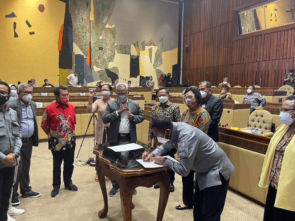   Wakil Ketua Pansus RUU Perubahan Kedua UU Otsus Papua, Yan P Mandenas menandatangani berkas di depan sejumlah menteri, di ruang sidang DPR