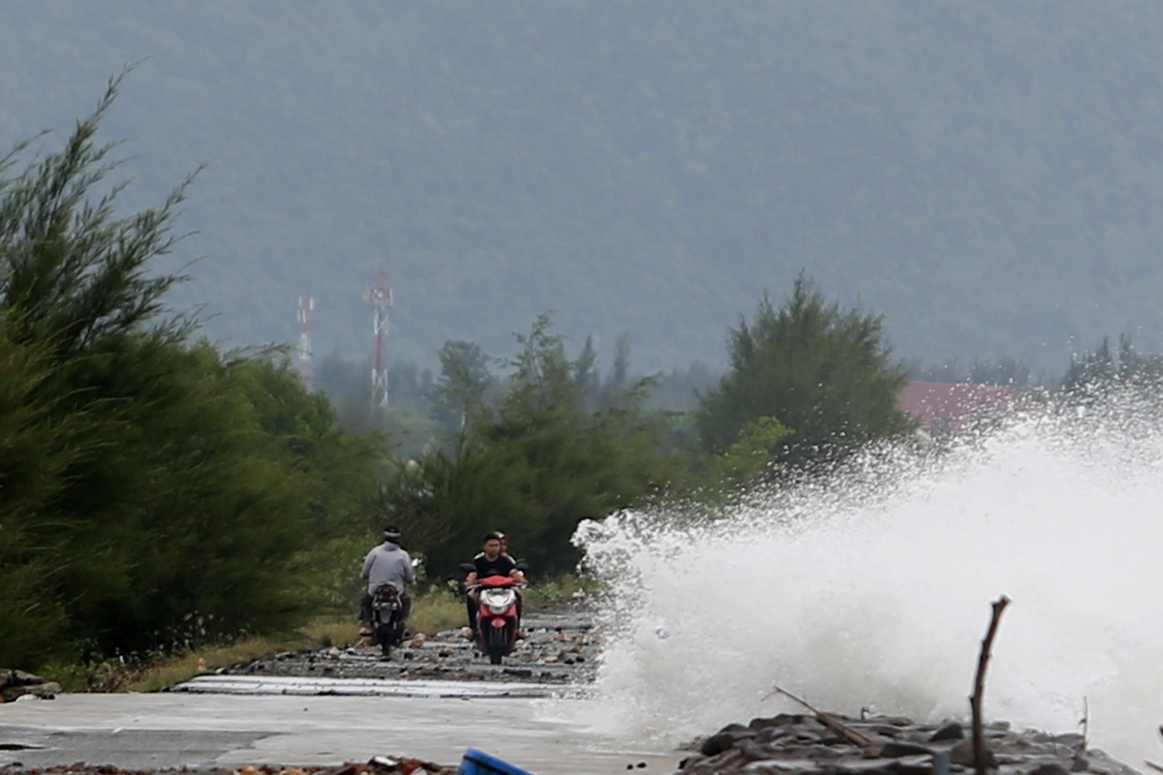 Gelombang tinggi melewati tanggul pemecah ombak di pesisir pantai Ulee Lheu, Banda Aceh, Aceh, Minggu (11/7/2021)