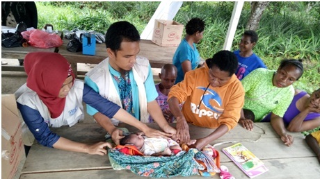 Tenaga medis Klinik Asiki (rompi putih) sedang memeriksa kesehatan bayi di Asiki, Boven Digoel, Papua.