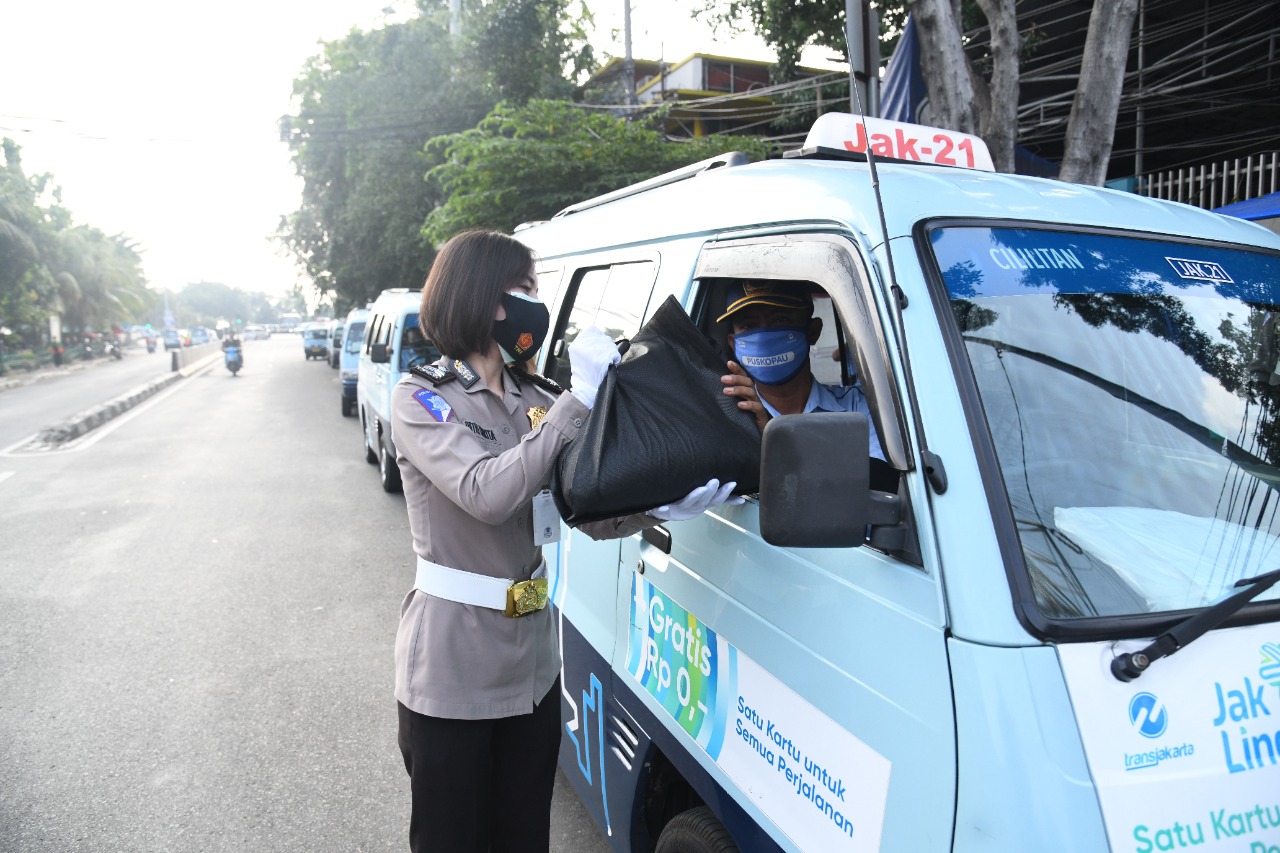 Polwan Korlantas Polri membagikan sembako bagi warga terdampak PPKM daurat seperti supir angkot, ojol dan PKL di DKI Jakarta, Jumat (16/7)