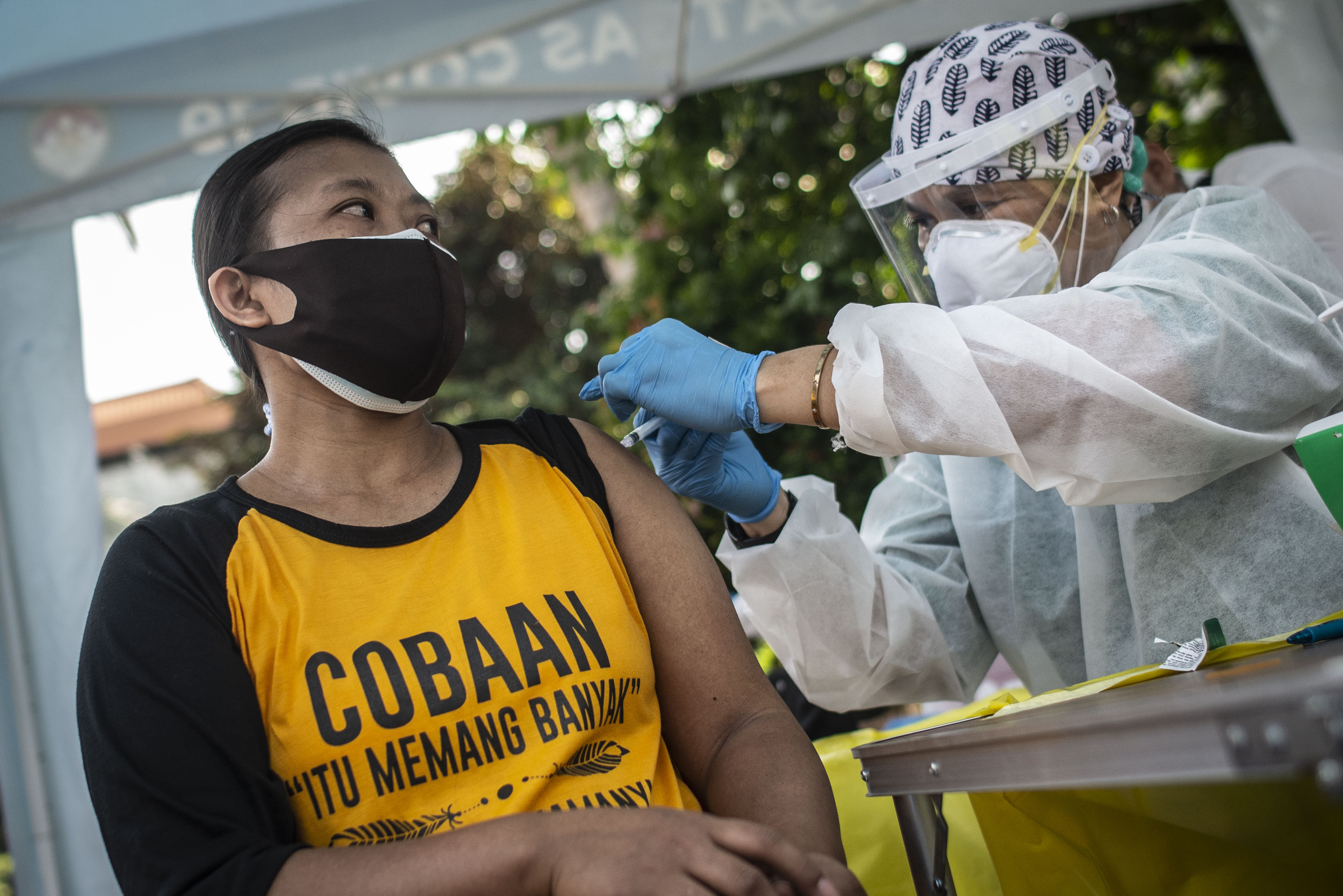  VAKSINASI KELILING: Tenaga kesehatan menyuntikkan vaksin kepada warga  melalui layanan mobil vaksin covid-19 keliling di Jakarta.