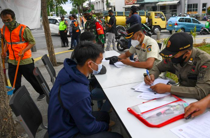 Petugas gabungan mendata warga pelanggar protokol kesehatan saat Operasi Yustisi Protokol Kesehatan covid-19 di kawasan Mampang, Jakarta.