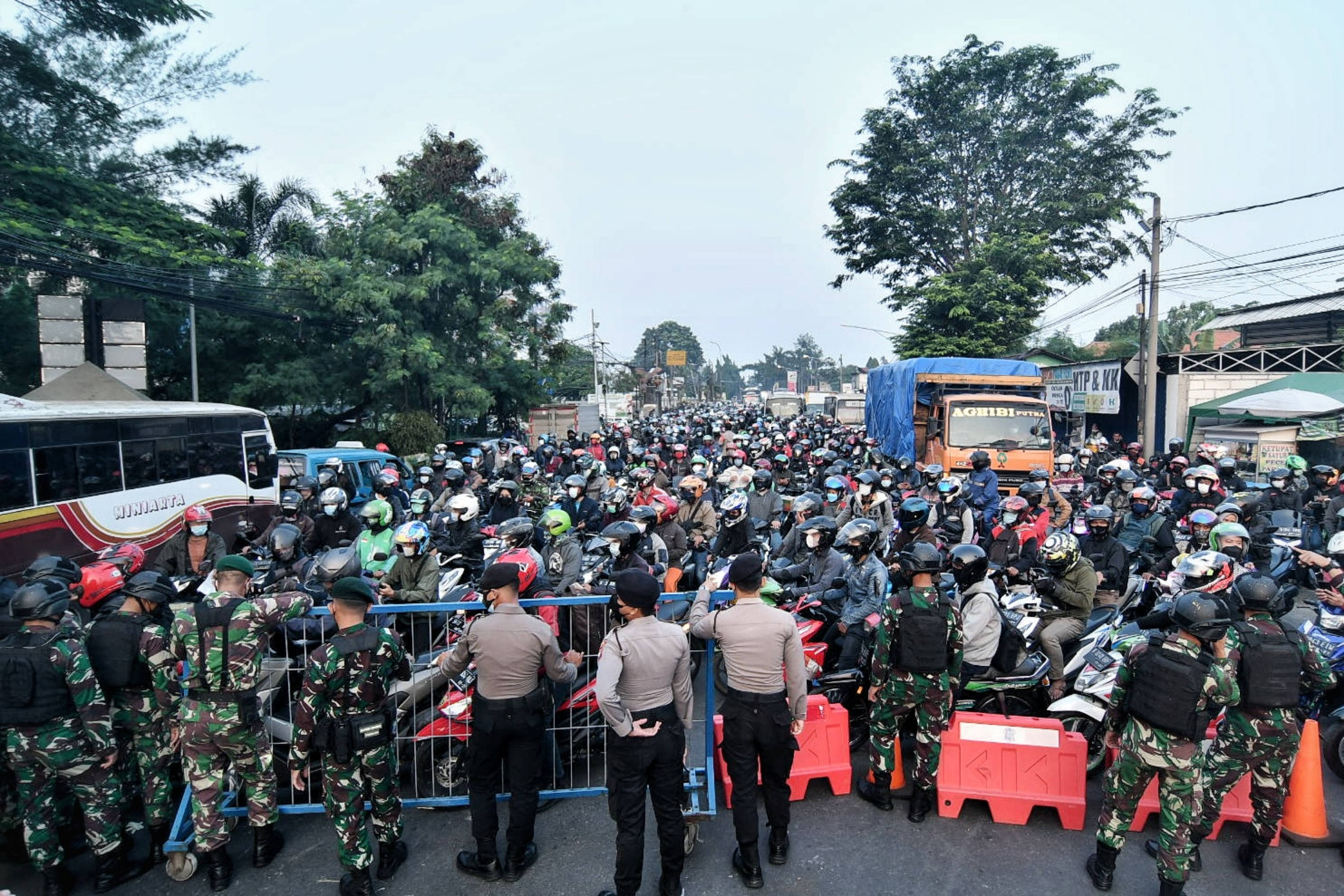  Sejumlah aparat TNI/Polri menjaga pos penyekatan jalan Raya Bogor, Jakarta, Senin (5/7/2021)