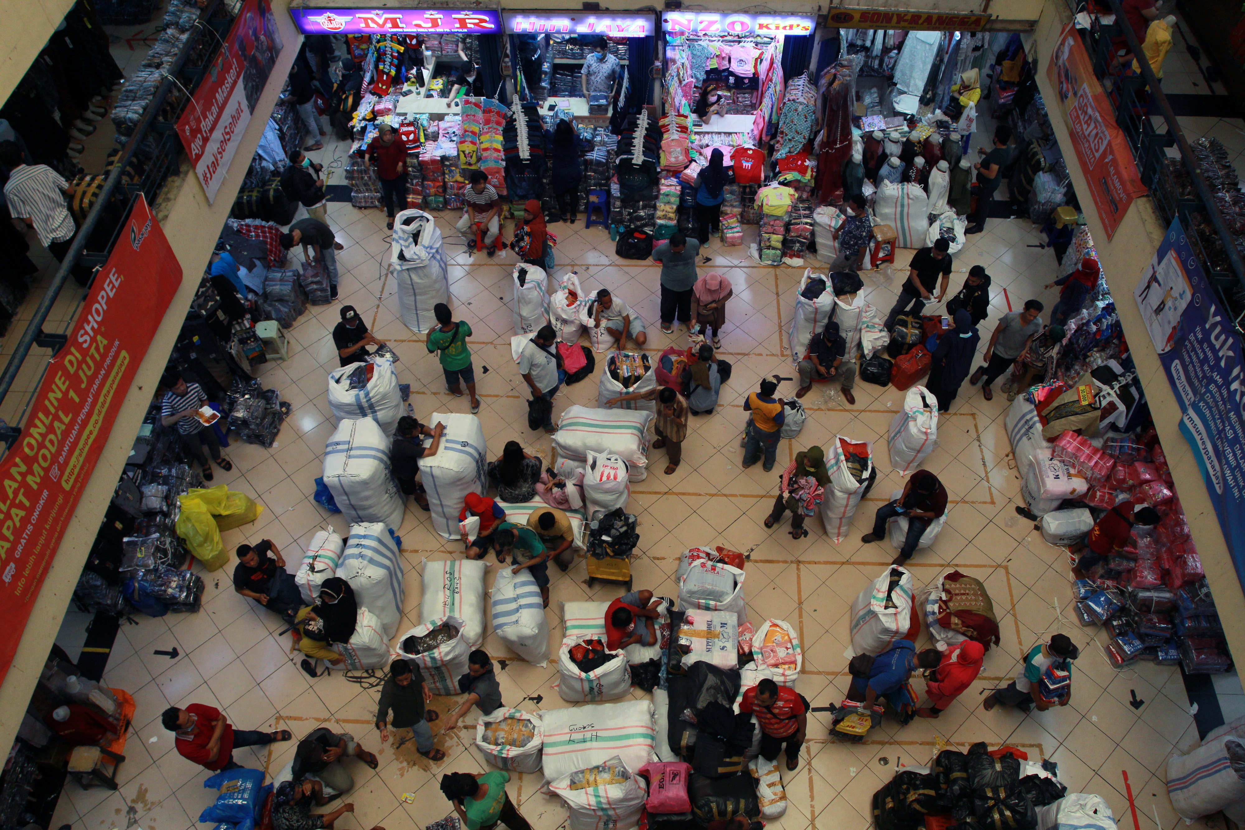ejumlah pedagang mengemas pakaian jadi yang laku terjual di Pusat Grosir Pasar Cipulir, Jakarta.