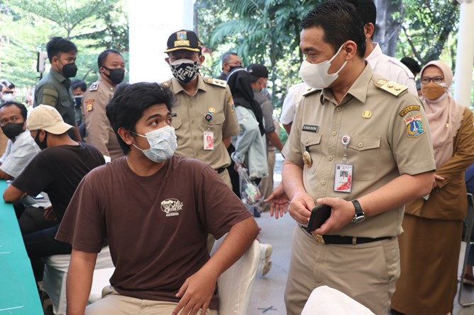Wagub DKI Jakarta Ahmad Riza Patria menyapa mahasiswa yang akan divaksinasi Covid-19 di kamps Unas, Jakarta Selatan, Senin (26/7)