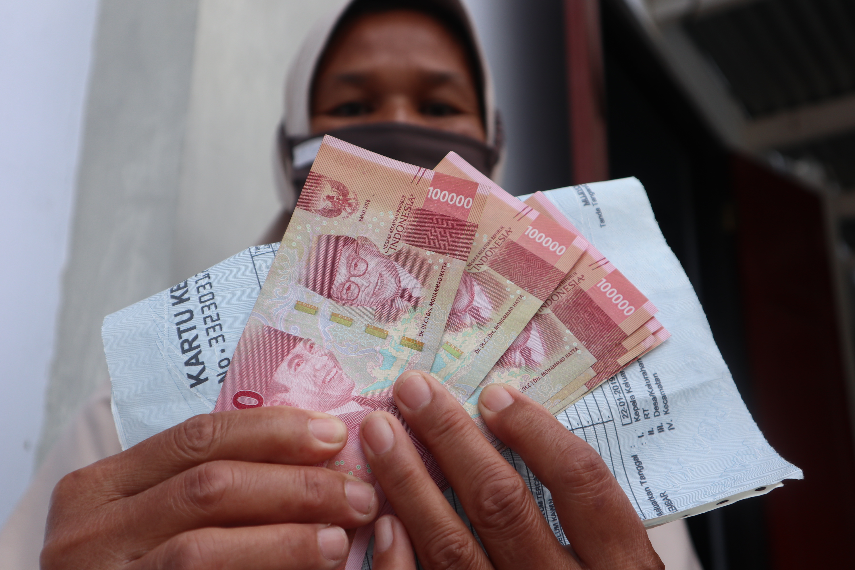 Seorang warga Kelurahan Madureso, Temanggung, Jawa Tengah menunjukan uang Bantuan Sosial Tunai (BST) yang diterimanya.