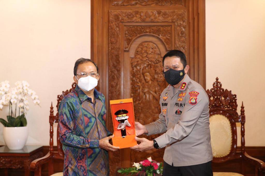 Kapolda Bali Irjen Putu Jayan Danu Putra (kanan) menyerahkan penghargaan Kapolri ke Gubernur Bali I Wayan Koster, Jumat (30/7).