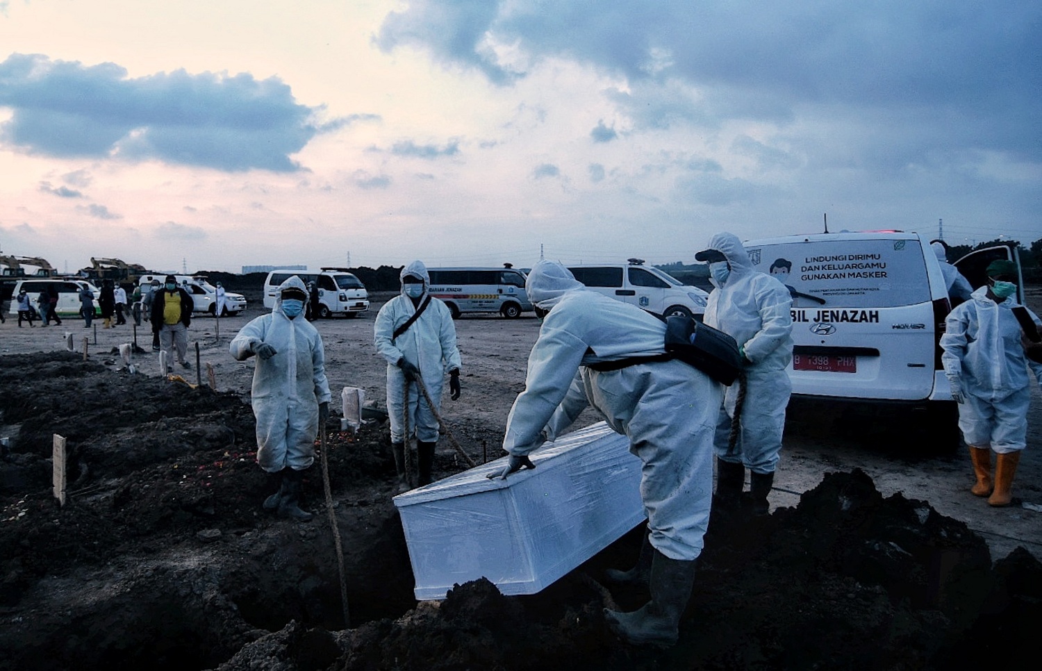 Petugas mengangkat jenazah korban covid-19 untuk dimakamkan di TPU Rorotan, Jakarta Utara, Minggu (27/6)