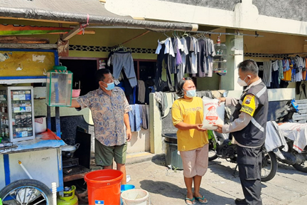 Personel Bhabinkamtibmas Polresta Surakarta berkeliling dari kamping ke kampung menyakurkan bantuan sosial beras. 