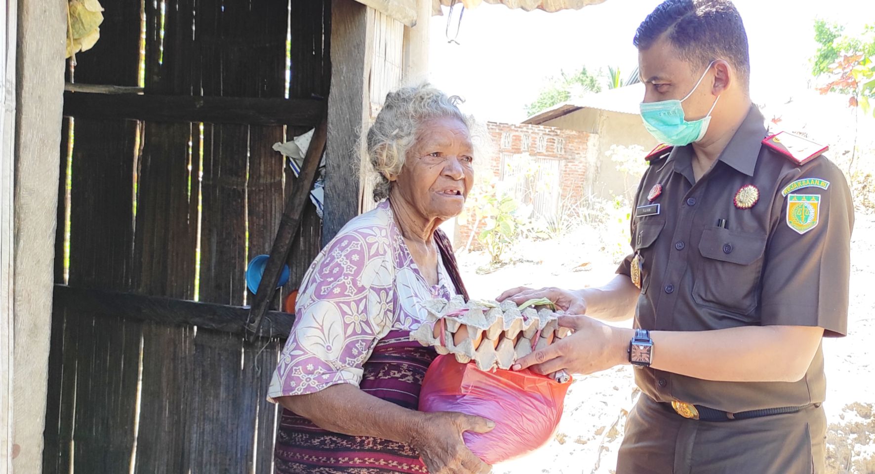 Kejari Sikka Fahmi (kanan) mengantarkan langsung bantuan sembako bagi warga miskin terdampak covid-19.