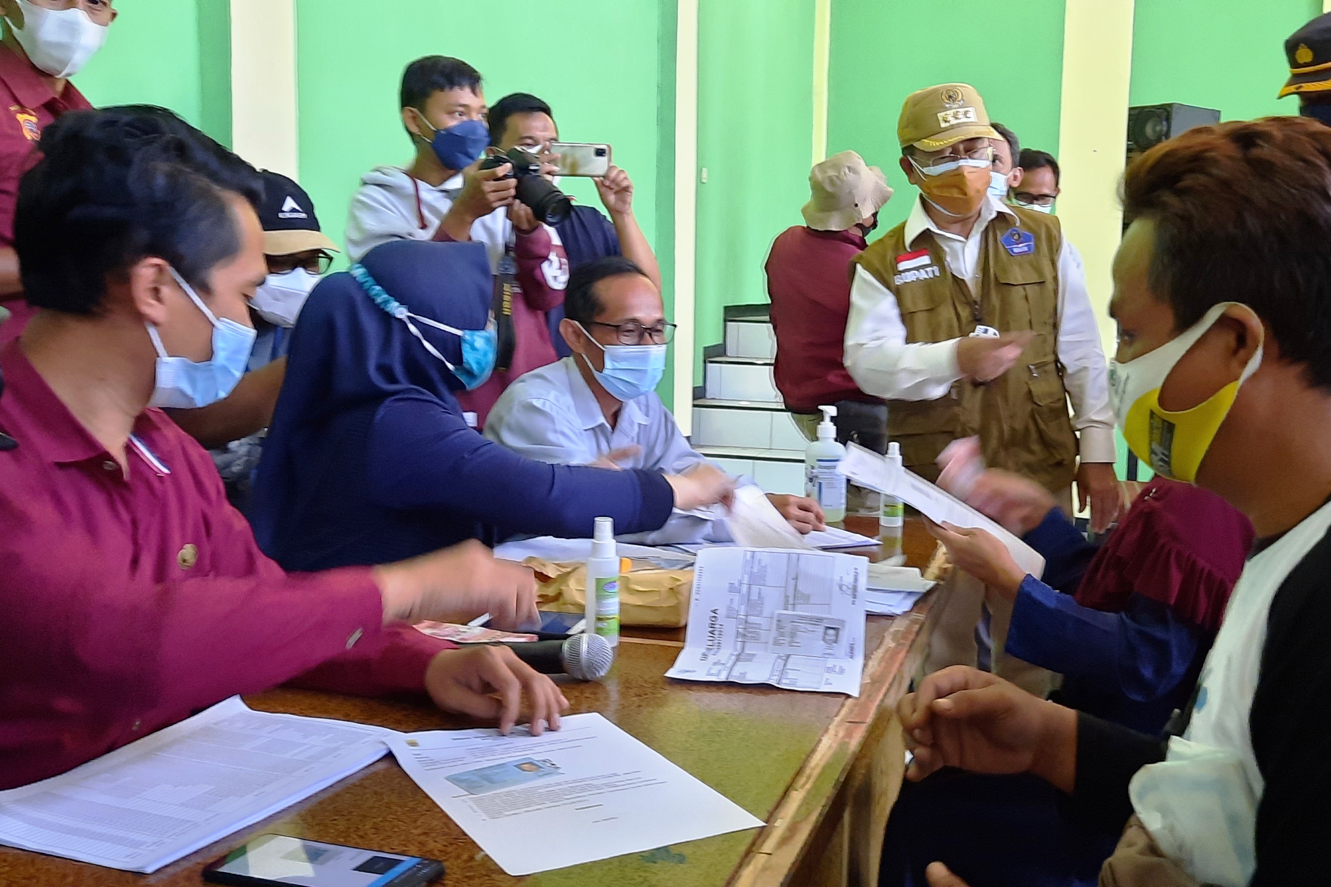  Bupati Cianjur, Herman Suherman, memantau pelaksanaan penyaluran bantuan sosial tunai PPKM darurat di aula Desa Nagrak Kecamatan Cianjur.