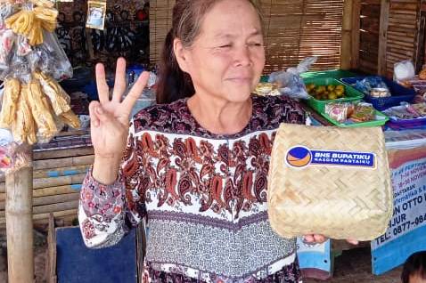 Seorang warga menerima paket daging kurban dari DPD Partai NasDem Kabupaten Cianjur, Jawa Barat.