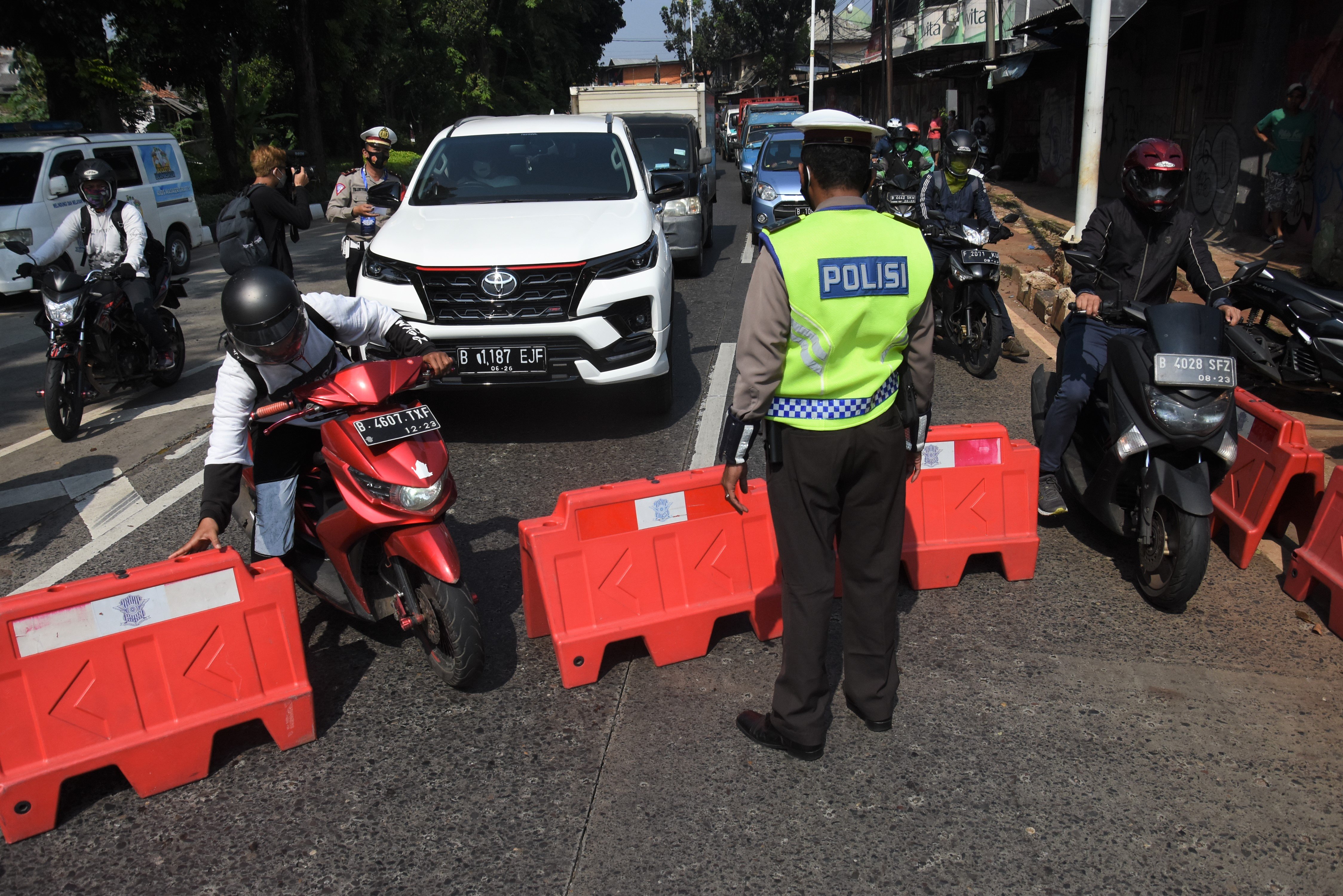 Polisi mengatur penyekatan pembatasan mobilitas masyarakat pada PPKM Darurat di Lenteng Agung, Jakarta, Sabtu (3/7/2021). 