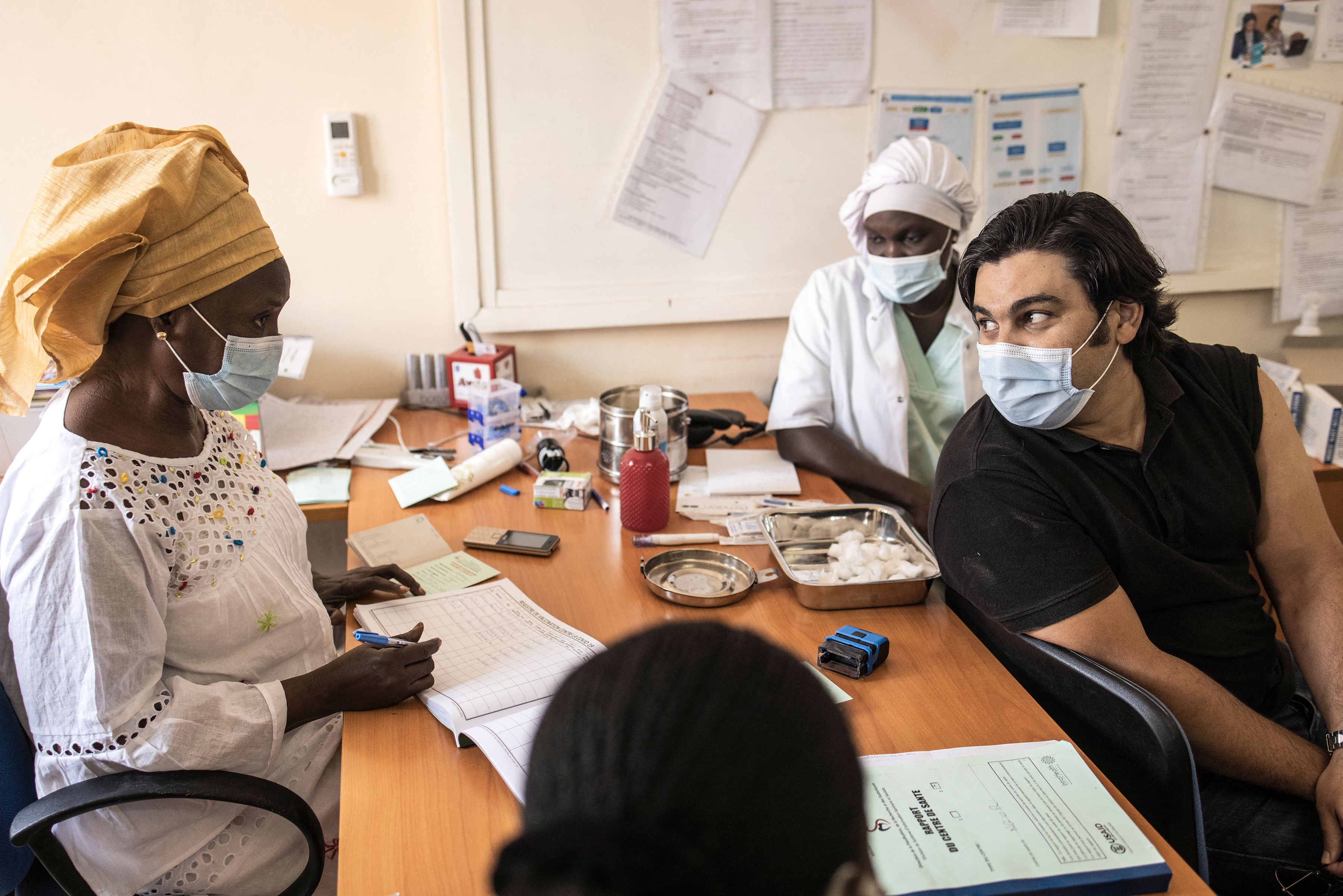 Seorang warga berbicara dengan tenaga kesehatan usai menerima vaksin covid-19 di Dakar, Senegal.