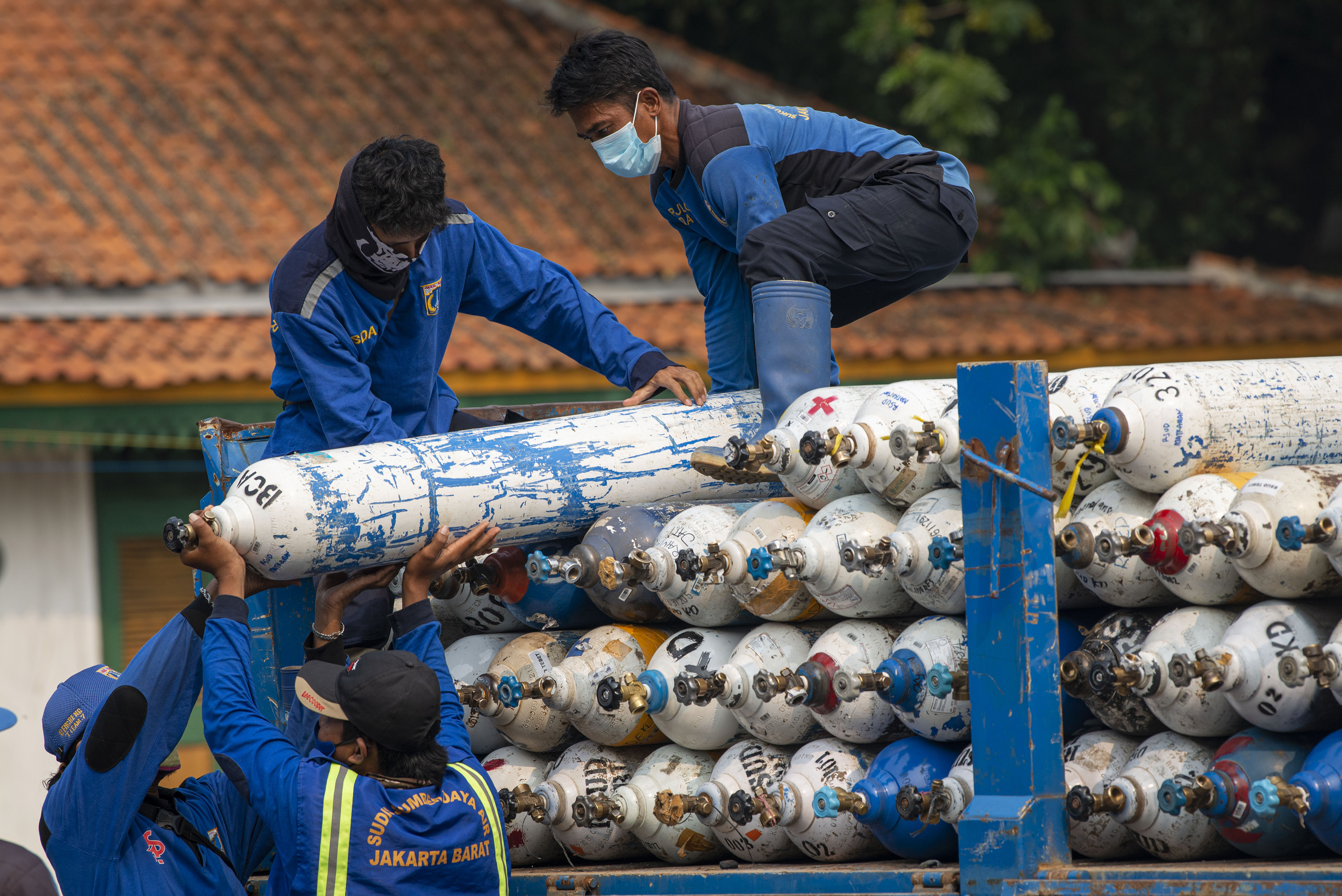 Ilustrasi petugas menurunkan tabung oksigen dari truk.