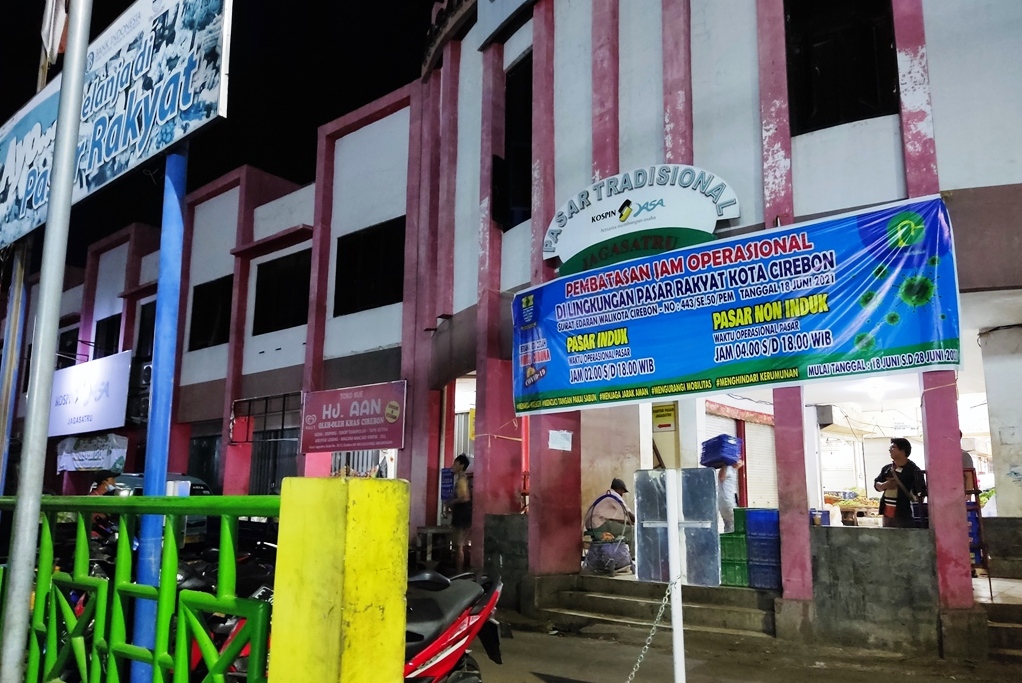 Spanduk berisi pemberitahuan jam operasional pasar di masa PPKM darurat terpasang di depan Pasar Induk Jagasatru, Kota Cirebon, Rabu (7/7).