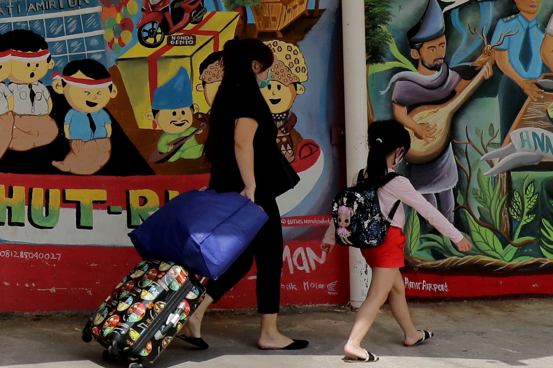Penumpang melintas di dekat mural di Bandara Depati Amir, Pangkalpinang, Kepulauan Bangka Belitung.
