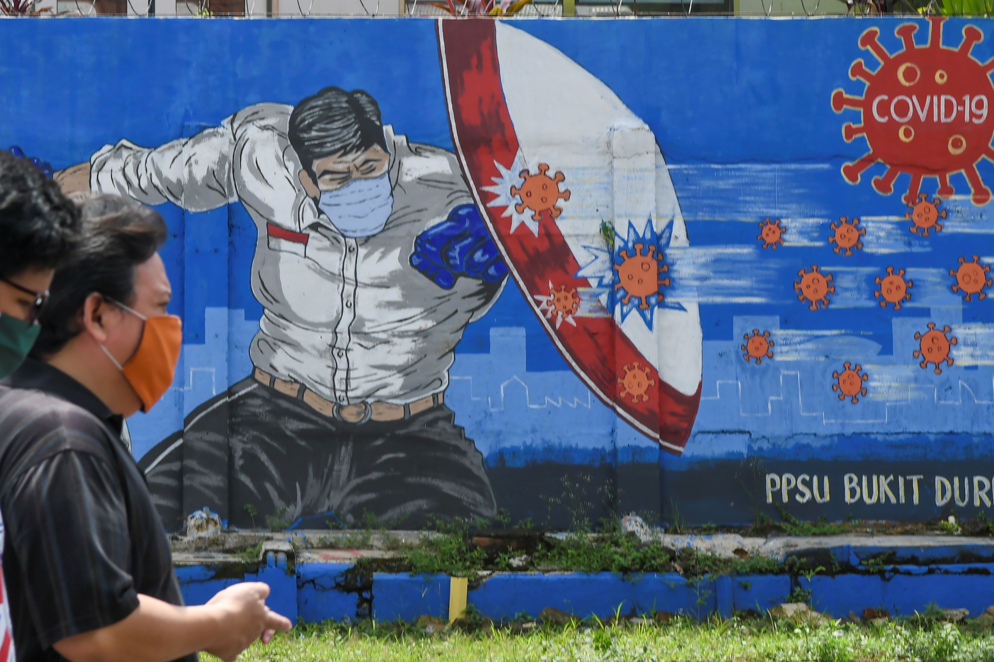 Warga melintas di depan mural tentang pandemi covid-19 di Bukit Duri, Jakarta.