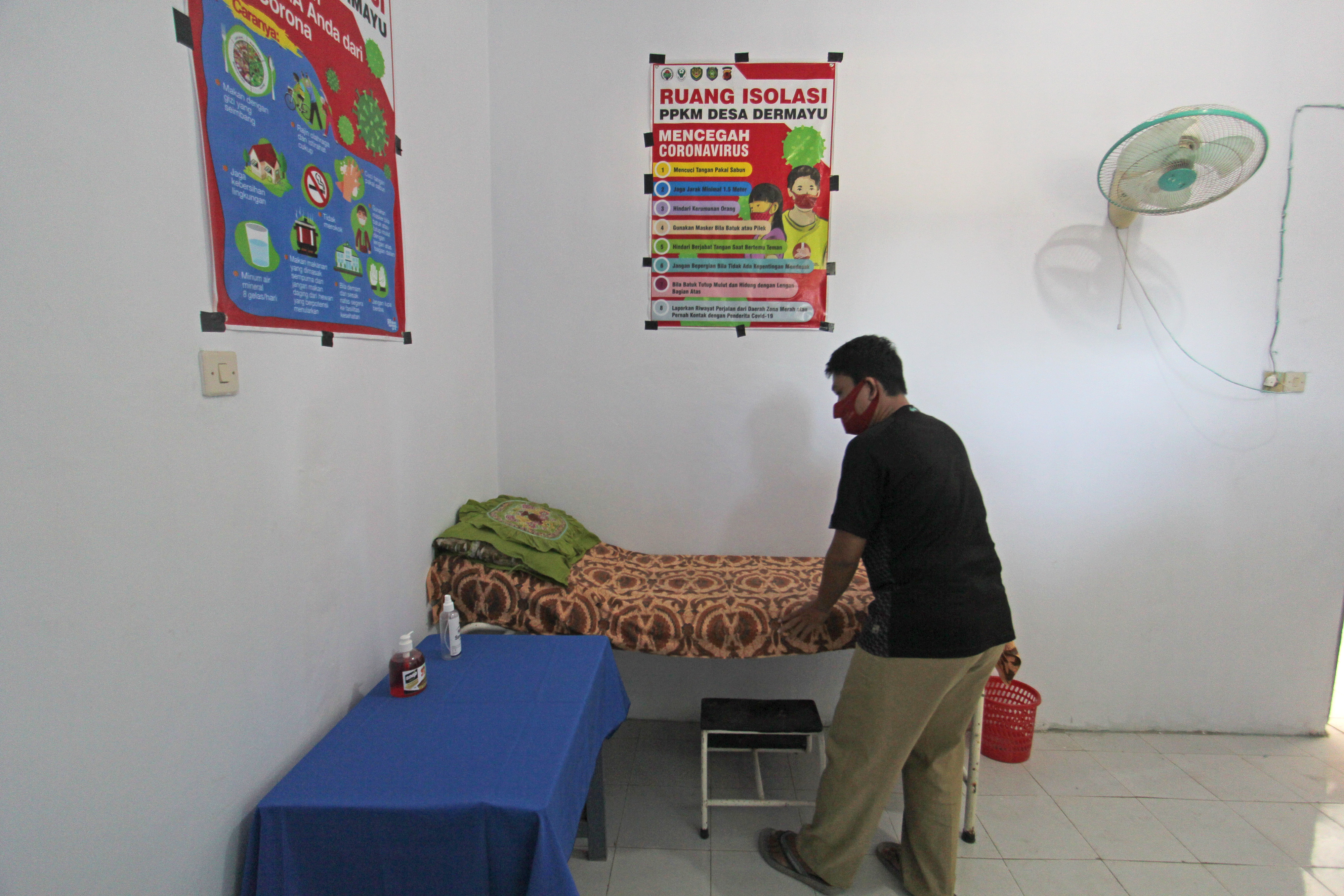 Perangkat desa menyiapkan kamar tidur untuk tempat isolasi mandiri di Balai Desa Dermayu, Sindang, Indramayu, Jawa Barat.