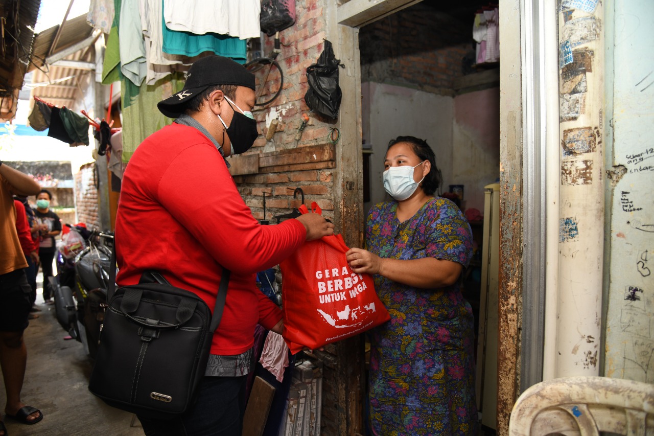 Relawan dari Komunitas Berbagi untuk Warga membagikan bantuan sembako bagi warga di Jakarta yang terdampak pandemi Covid-19.