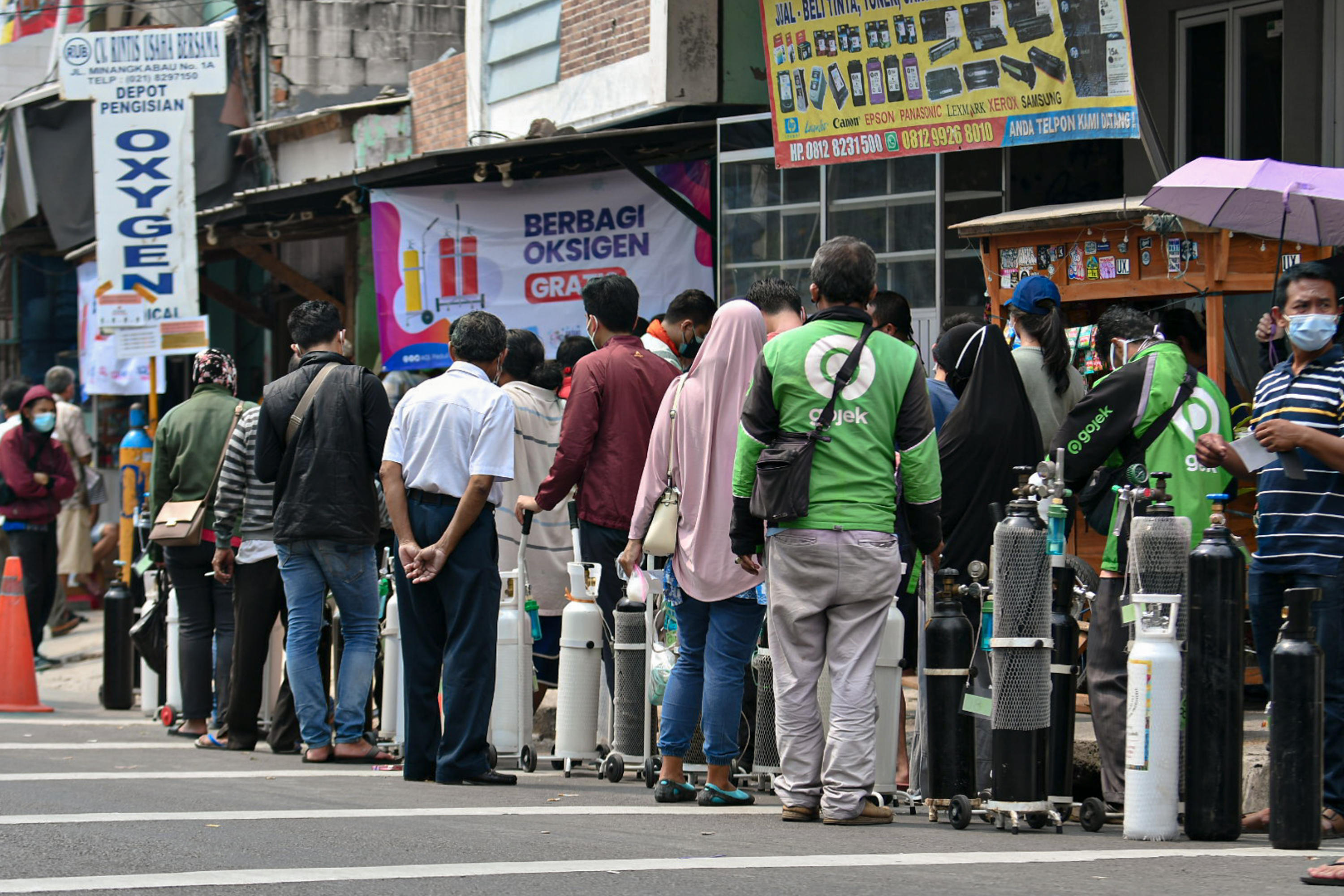 Sejumlah warga mengantre untuk mengisi ulang oksigen medis yang dibagikan secara gratis di kawasan Manggarai, Jakarta, Kamis (15/7).