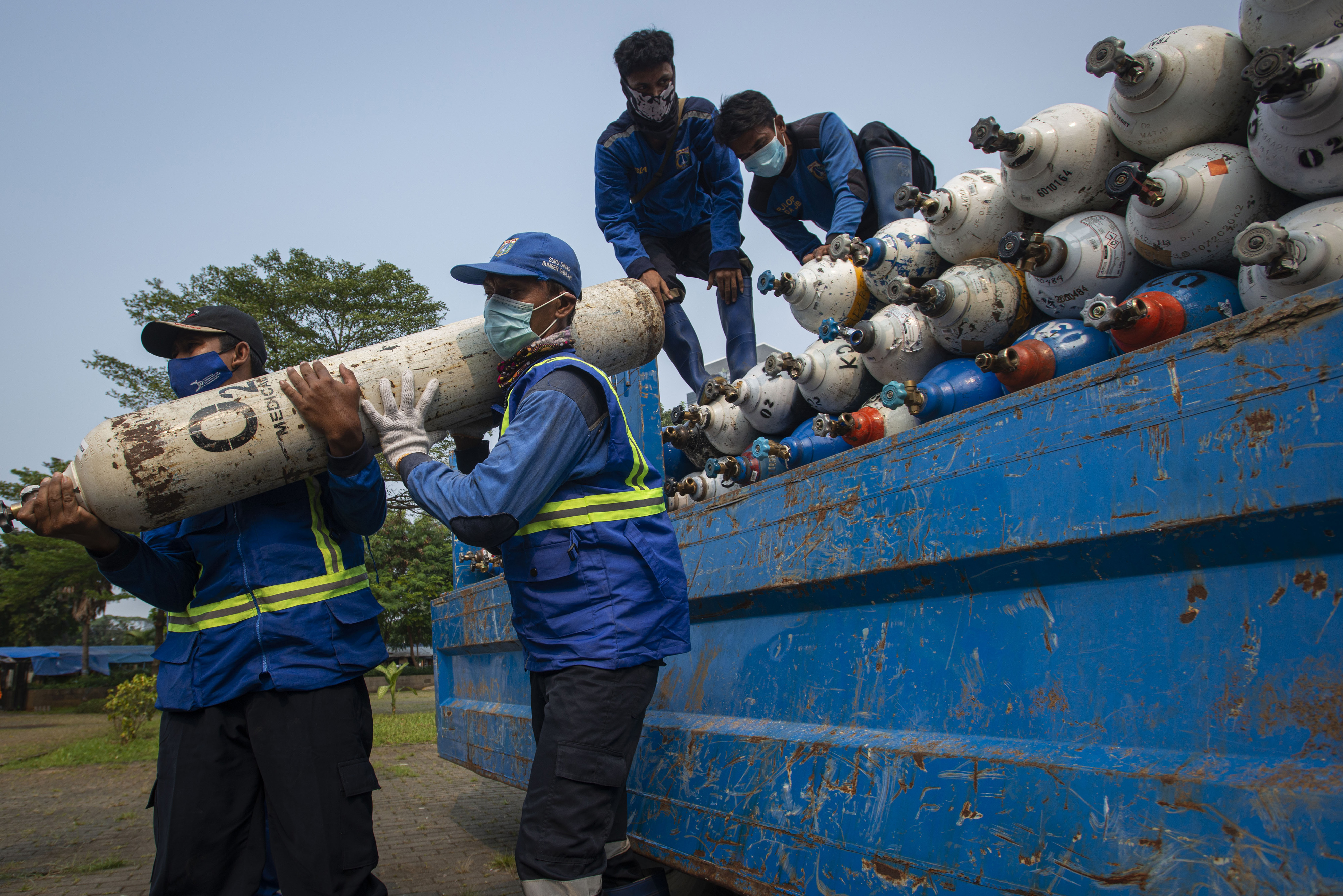 Petugas menurunkan tabung oksigen di Posko Darurat Oxygen Rescue di Monas, Jakarta.