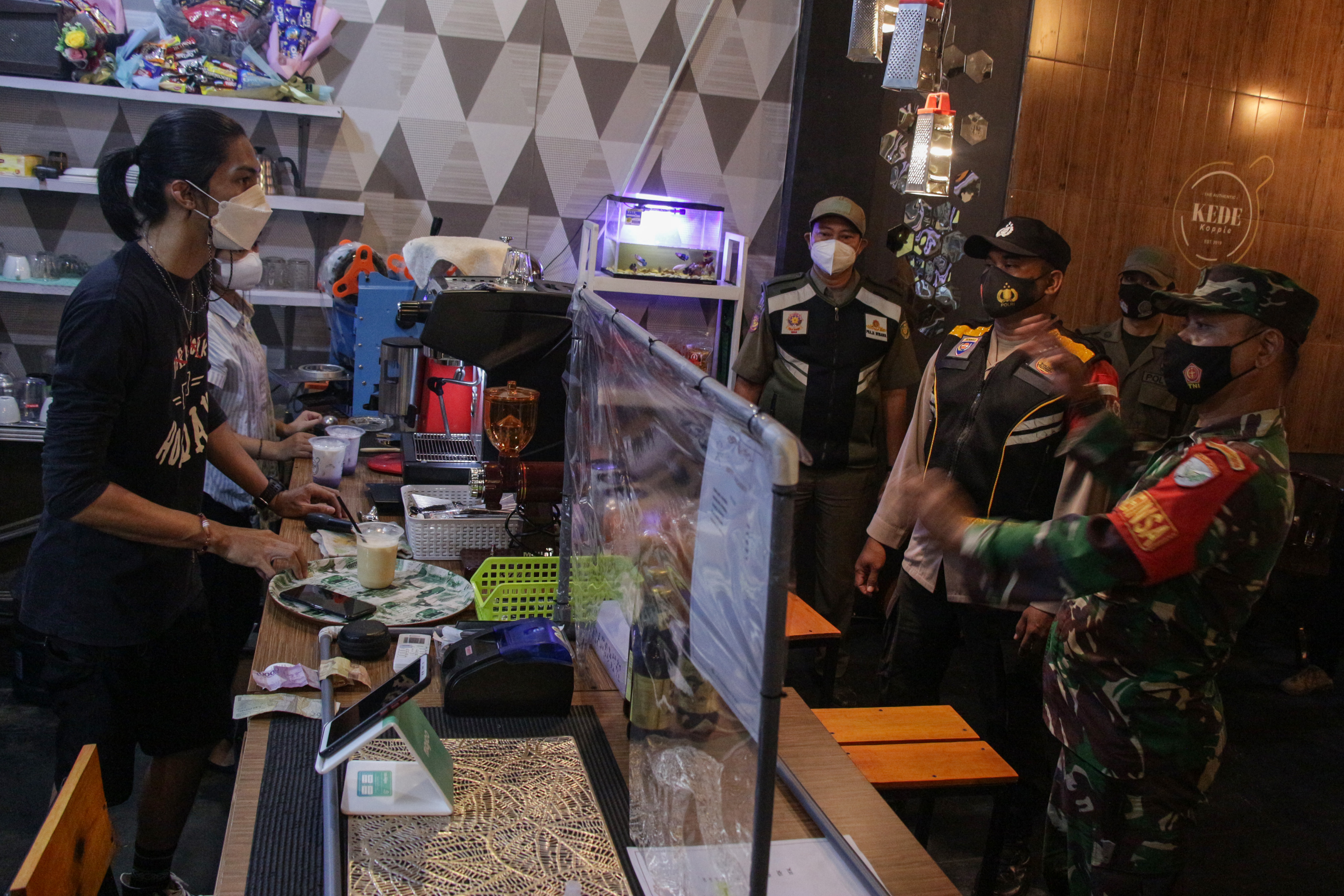 Petugas gabungan memberikan informasi soal pembatasan jam operasional usaha di Kalimantan Tengah