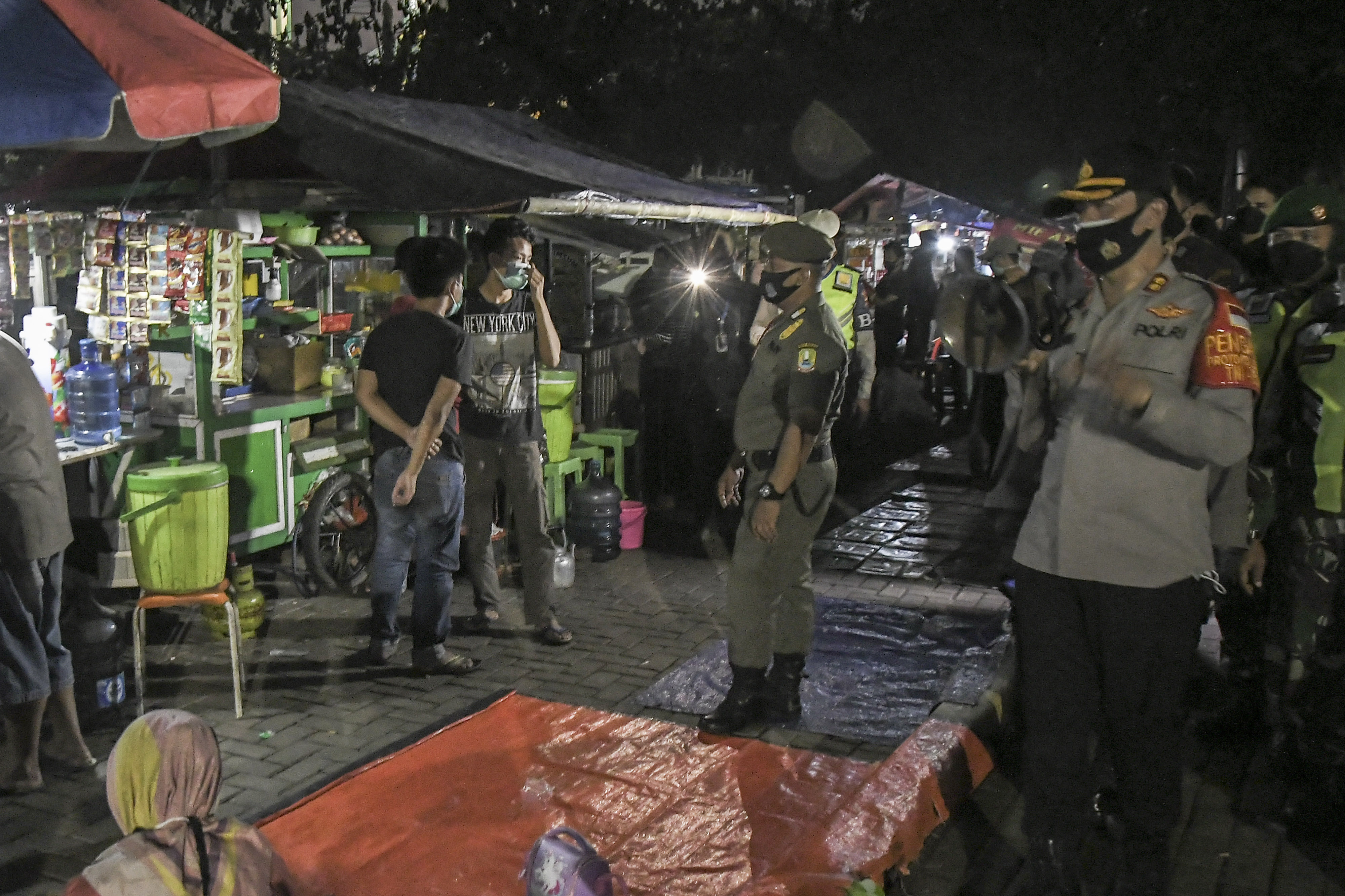 Petugas mengimbau pengunjung dan pedagang mematuhi protokol kesehatan saat operasi yustisi covid-19 di Alun-alun Bekasi, Jawa Barat.