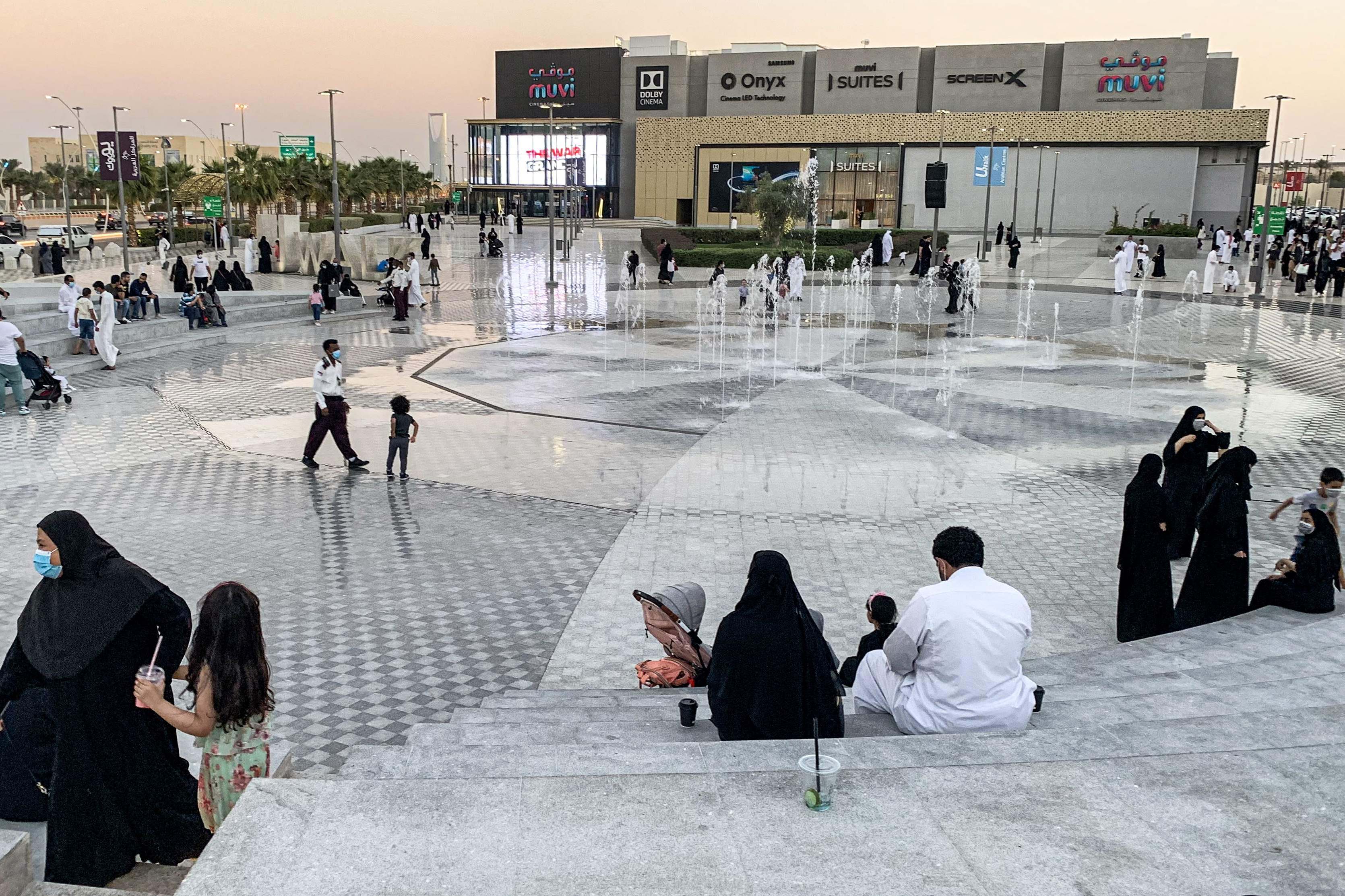 Orang-orang duduk dekat air mancur, di luar pusat perbelanjaan, ibu kota Arab Saudi, Riyadh, 31 Oktober 2020.