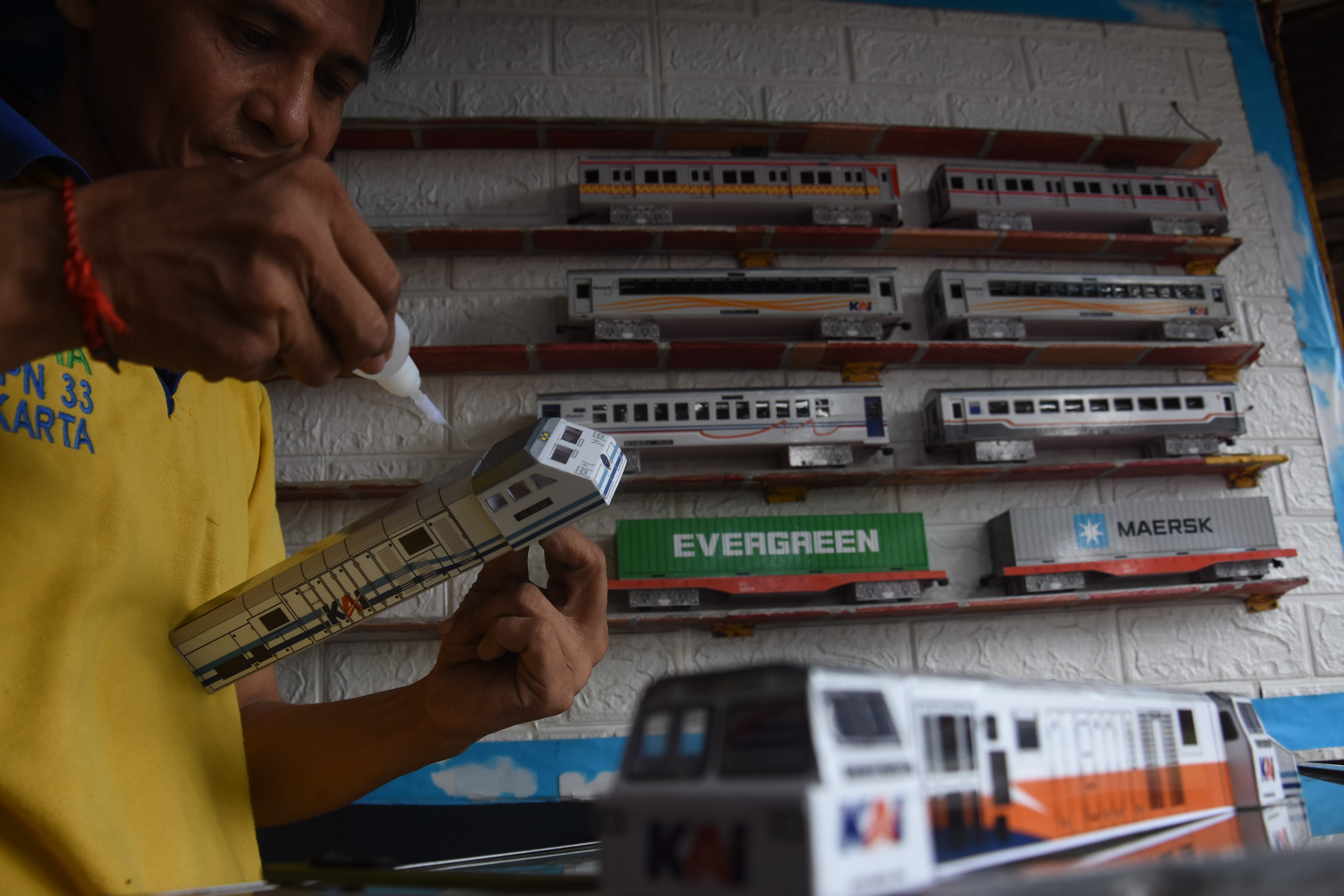 Perajin menyelesaikan pembuatan miniatur kereta di kiosnya di kawasan Manggarai, Jakarta, Senin (12/7).