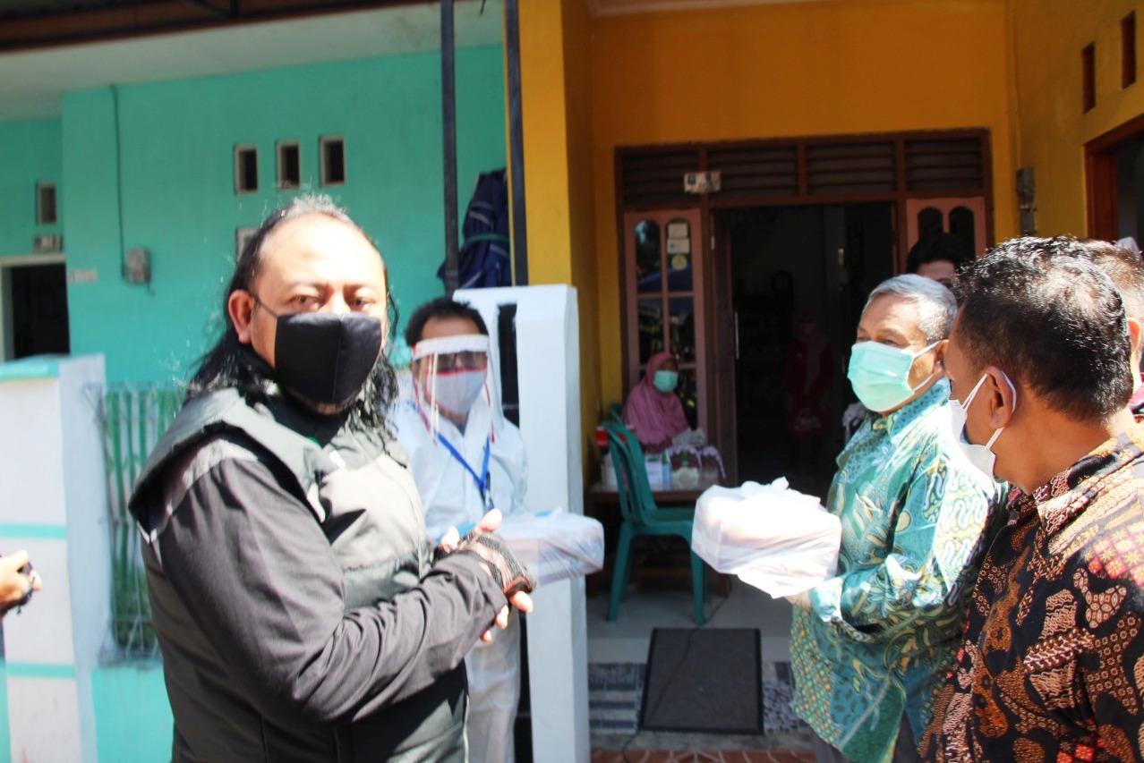Wali Kota Tegal Dedy Yon Supriyono (berjaket rambut gondrong) sedang menyerahkan makanan. 