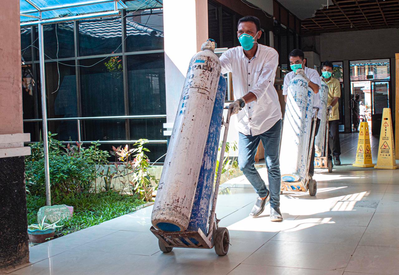 Petugas membawa tabung oksigen untuk didistribusikan ke RS di Palu
