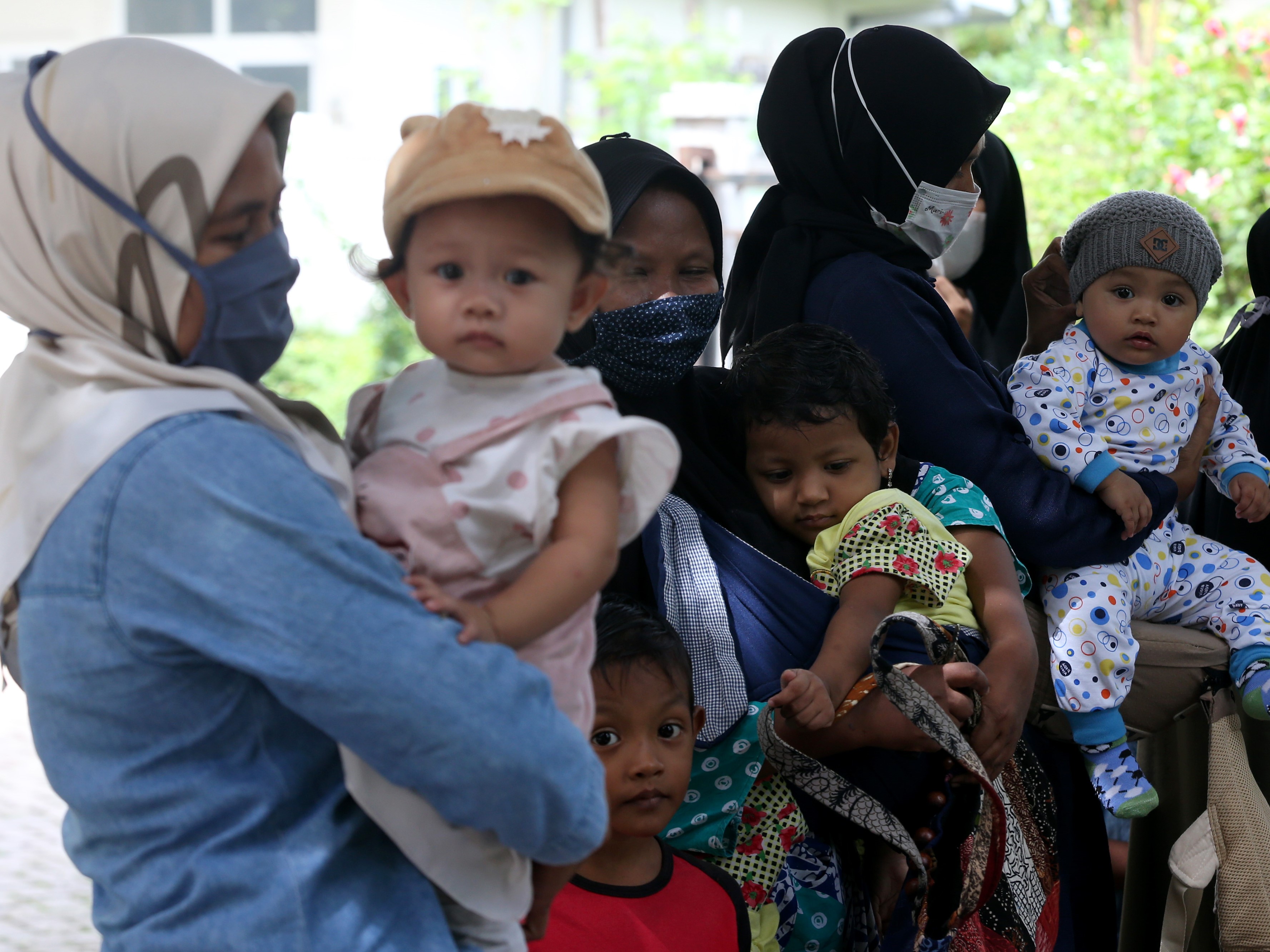 Warga membawa balita untuk mendapatkan imunisasi di Posyandu Banda Aceh, Aceh, Kamis (8/7), meskipun kota itu masuk zona merah covid-19.