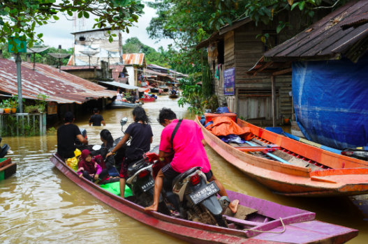 Sejumlah warga menaiki perahu melintasi banjir yang merendam permukiman di Desa Lesabela, Kecamatan Ledo, Kabupaten Bengkayang, Kalbar.