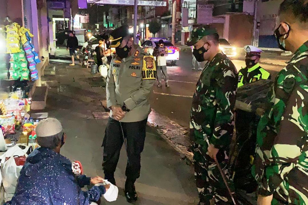 Kapolresta Tasikmalaya, AKBP Doni Hermawan borong penjual kerupuk yang tengah tertidur bersama anaknya di emperan toko.