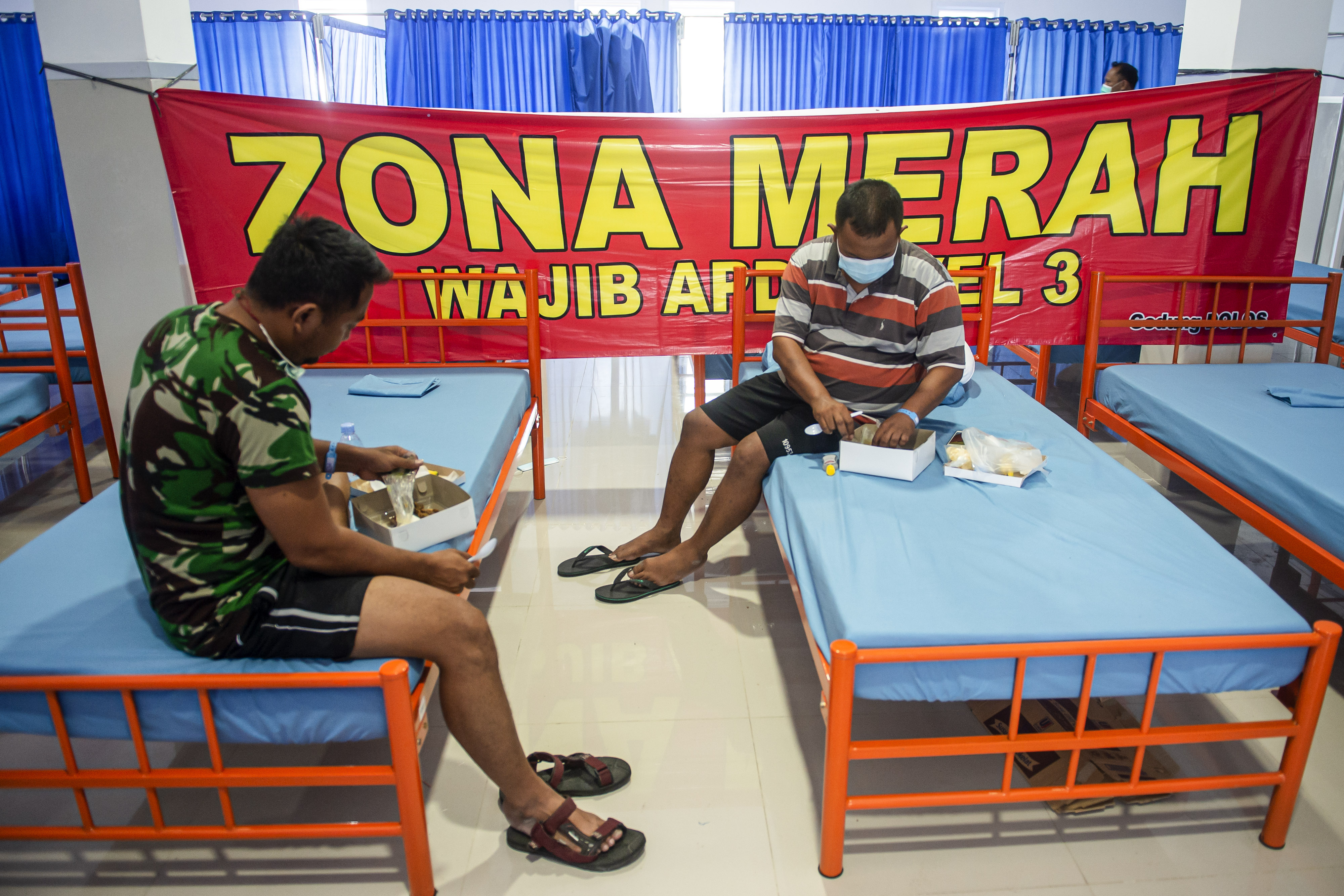 Dua pasien covid-19 dengan gejala ringan menyantap hidangan di ruang isolasi di Rumah Sakit Darurat Pangkalan Marinir Jakarta.