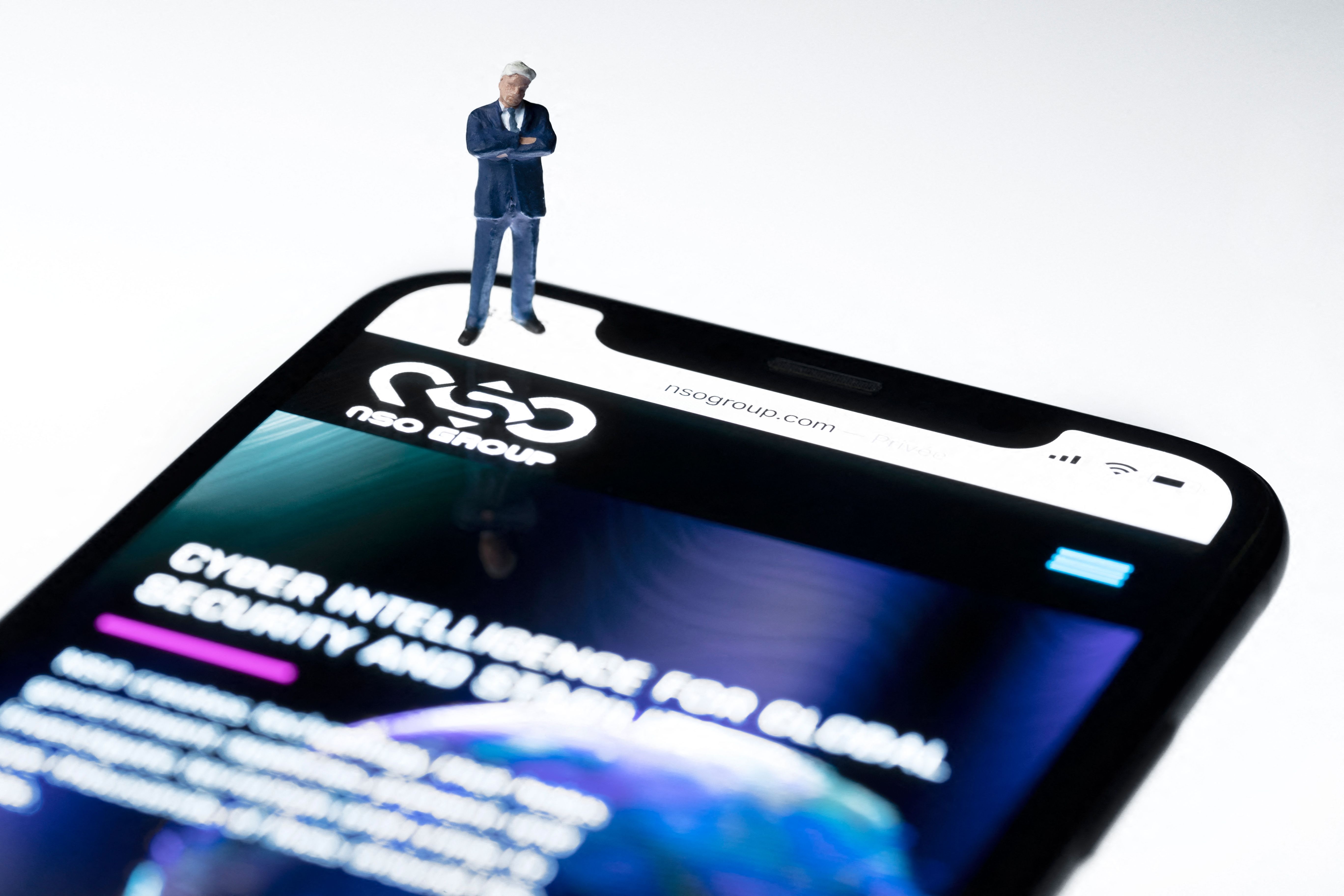 Foto ilustrasi yang menampilkan ponsel dengan laman daring NSO, perusahaan Israel yang memproduksi spyware Pegasus.