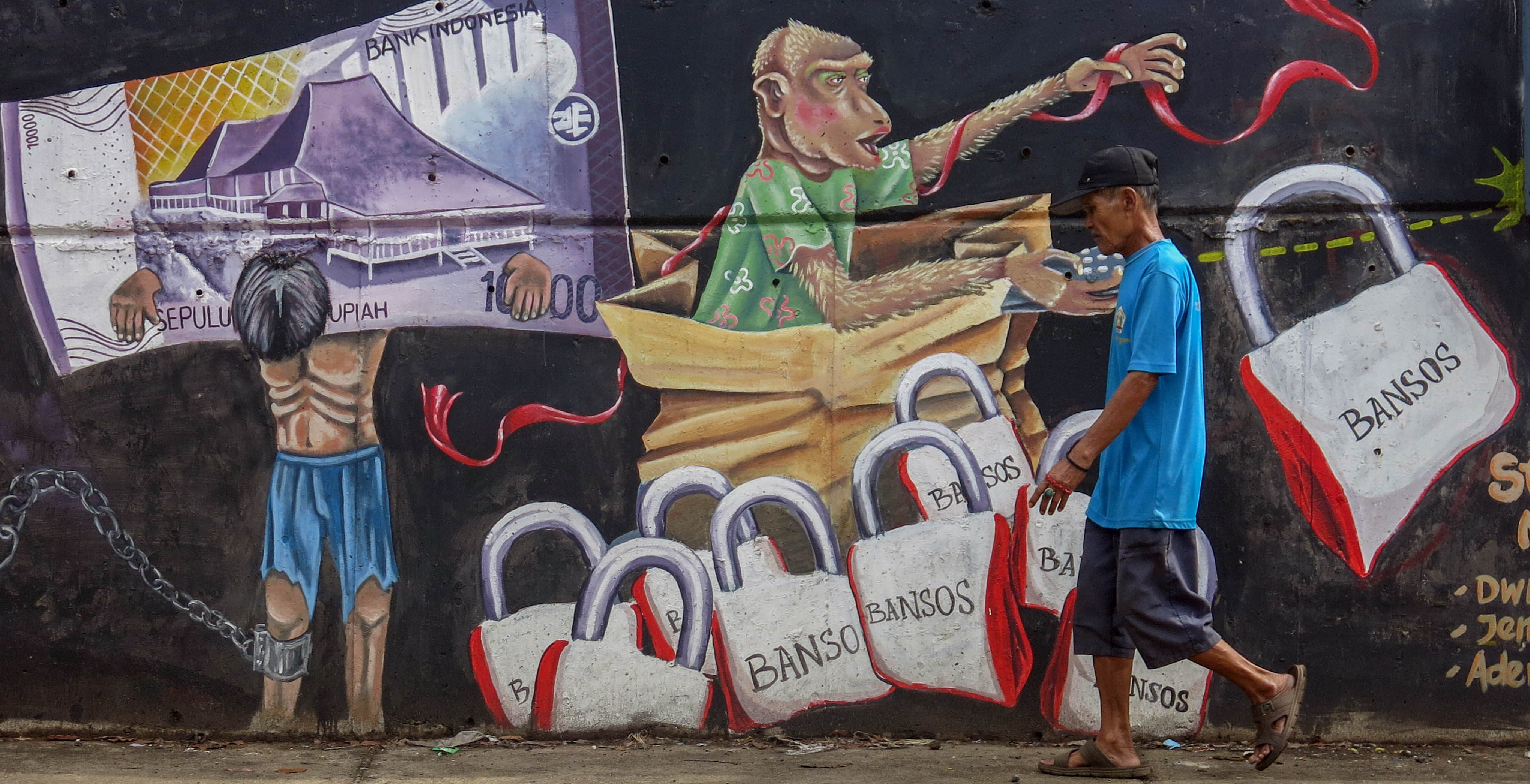 Warga melintasi mural bertema korupsi di Cileungsi, Kabupaten Bogor, Jawa Barat.