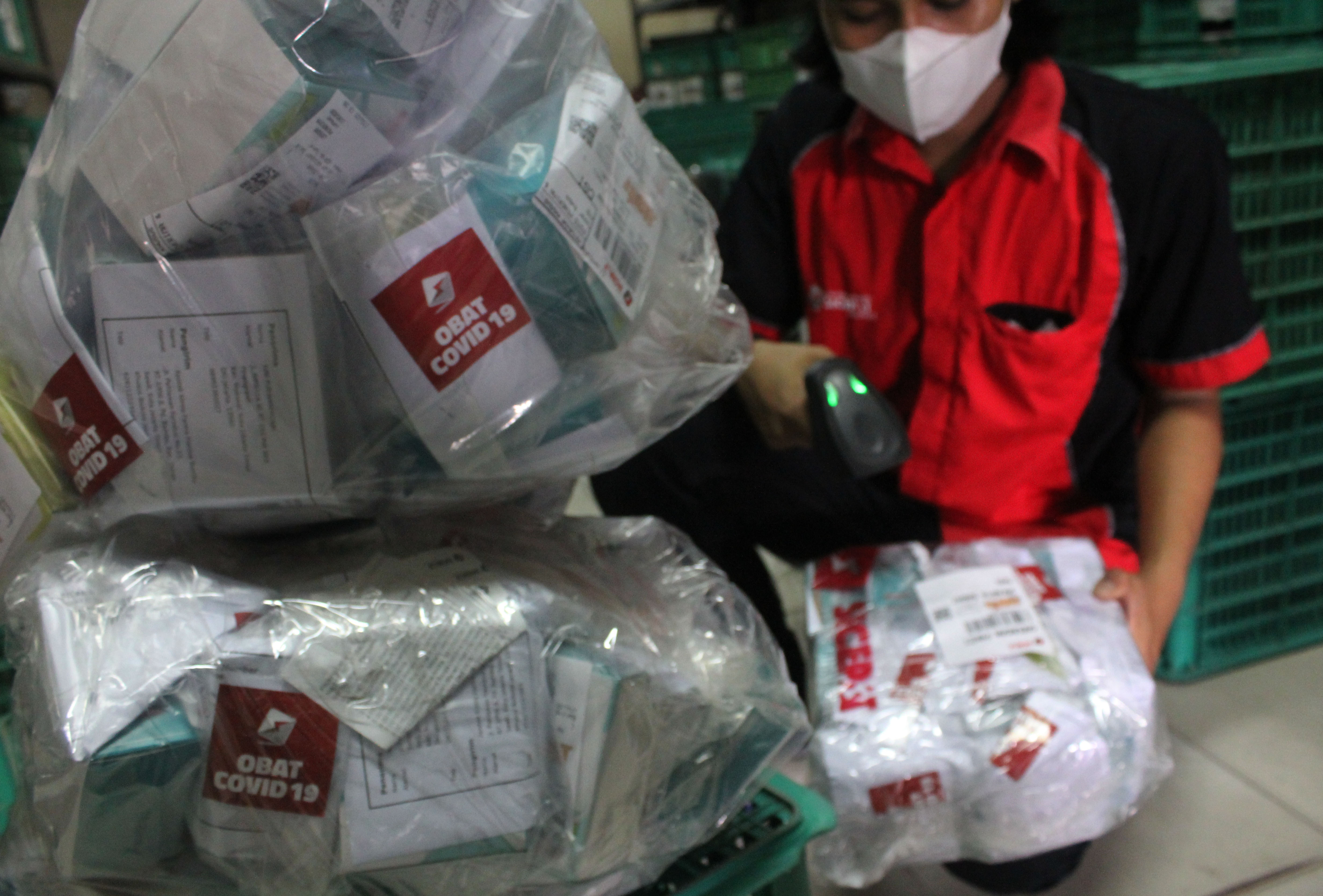Pekerja melakukan pengecekan paket obat covid-19 untuk didistribusikan di gerai jasa ekspedisi, Petamburan, Jakarta, Sabtu (17/7/2021). 