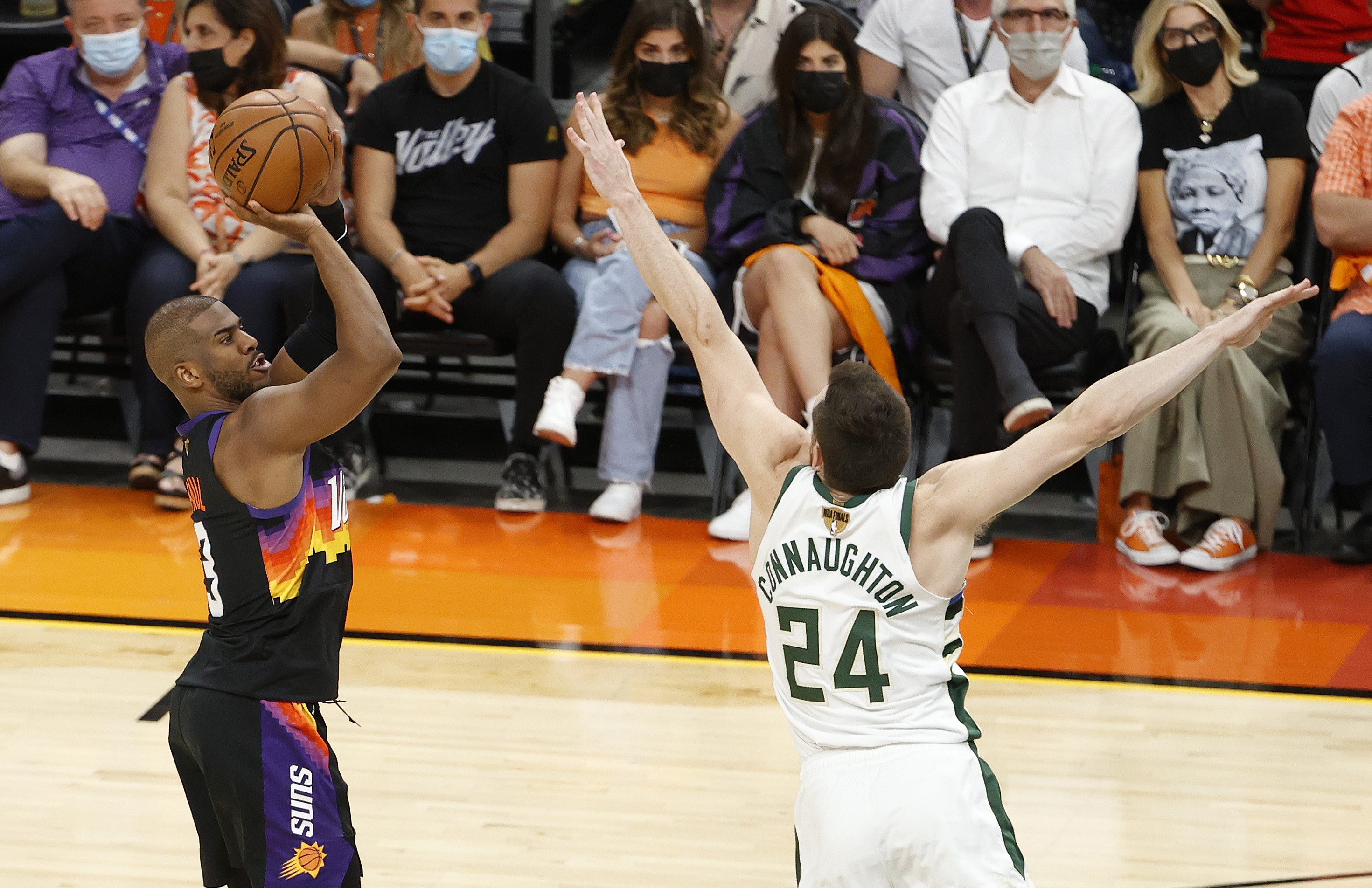 Pemain Phoenix Suns Chris Paul (kiri) melepaskan tembakan dalam Gim 1 final NBA melawan Milwaukee Bucks.