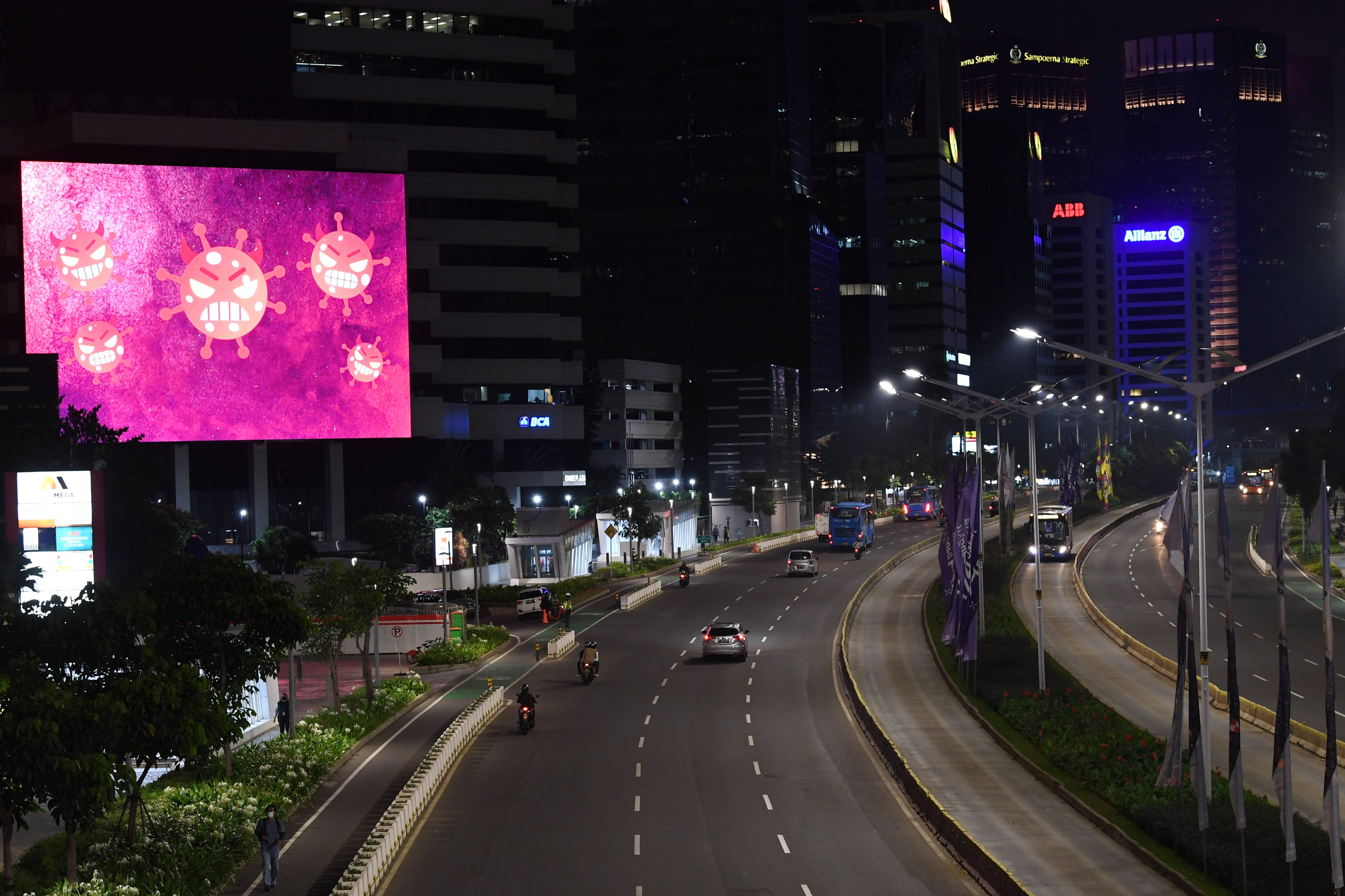 Suasana lengang kawasan Jalan Sudirman saat pelaksanaan PPKM Darurat di Jakarta, Senin (5/7/2021).