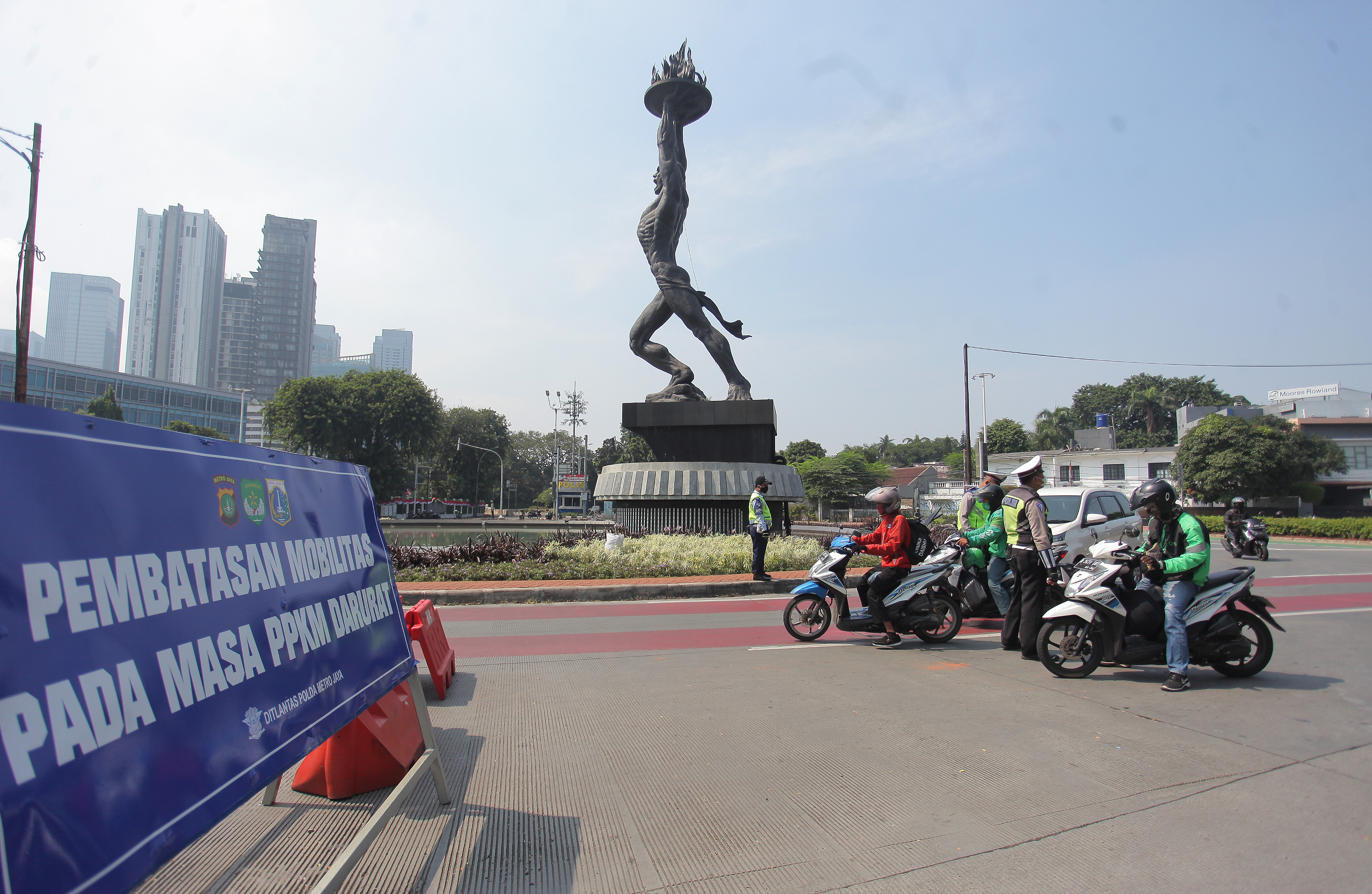 Polisi memeriksa kendaraan di tempat penyekatan PPKM Darurat di kawasan Jalan Jenderal Sudirman, Jakarta.