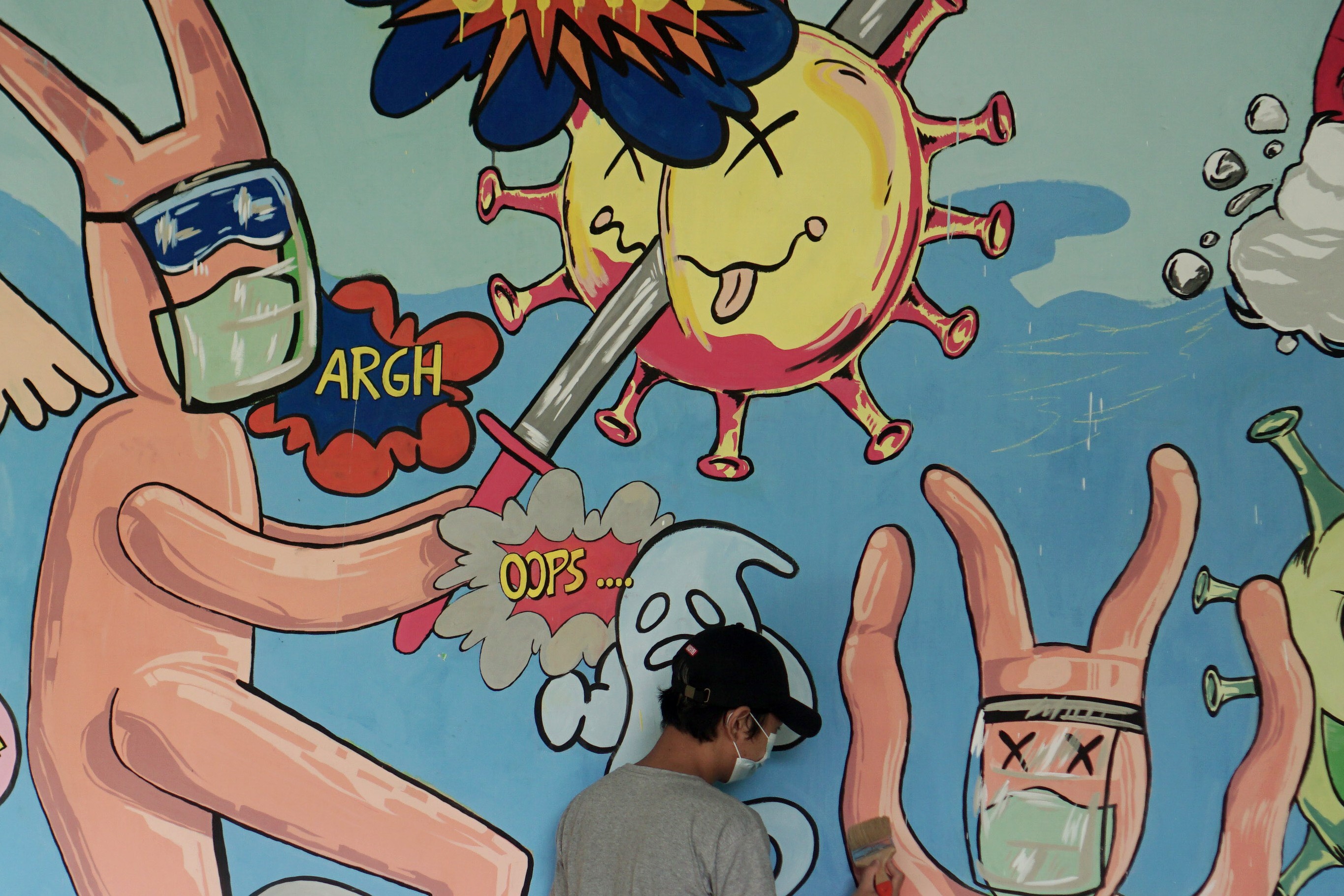 Mahasiswa menggambar mural bertema penanganan covid-19 di Balai Desa Gawanan, Colomadu, Karanganyar, Jawa Tengah.