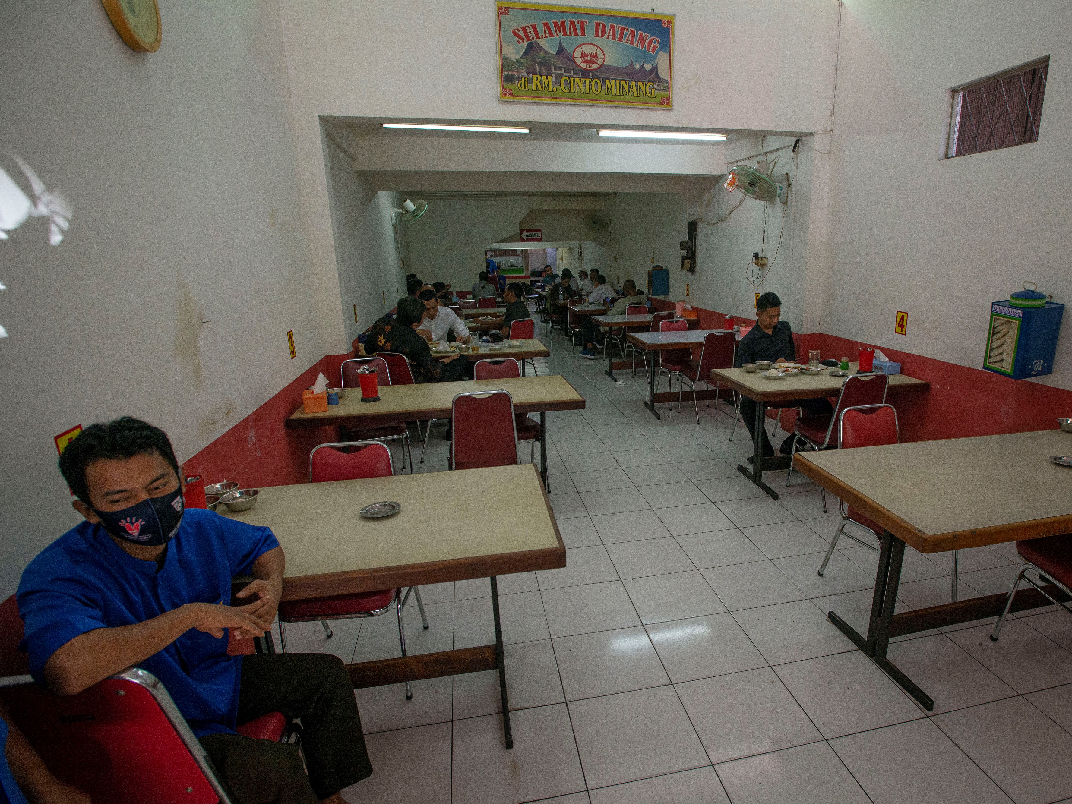 Sejumlah warga menyantap sajian yang dijual salah satu warung makan di Kemayoran, Jakarta, Senin (26/7).