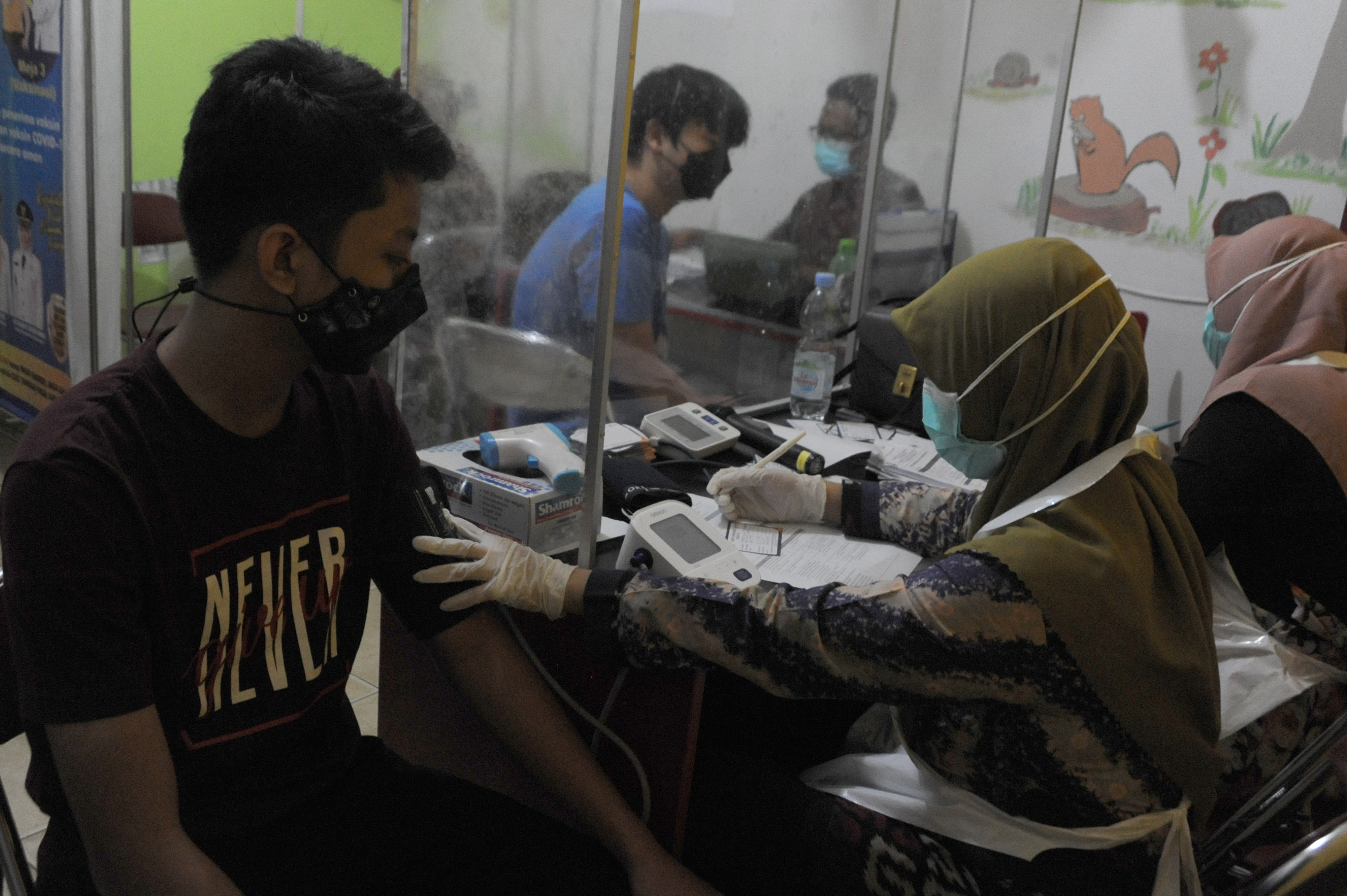 VAKSIN COVID BAGI ANAK: Petugas melakukan pemeriksaan terhadap penerima vaksin usia 12-17 di Puskesmas Alang alang Lebar Palembang