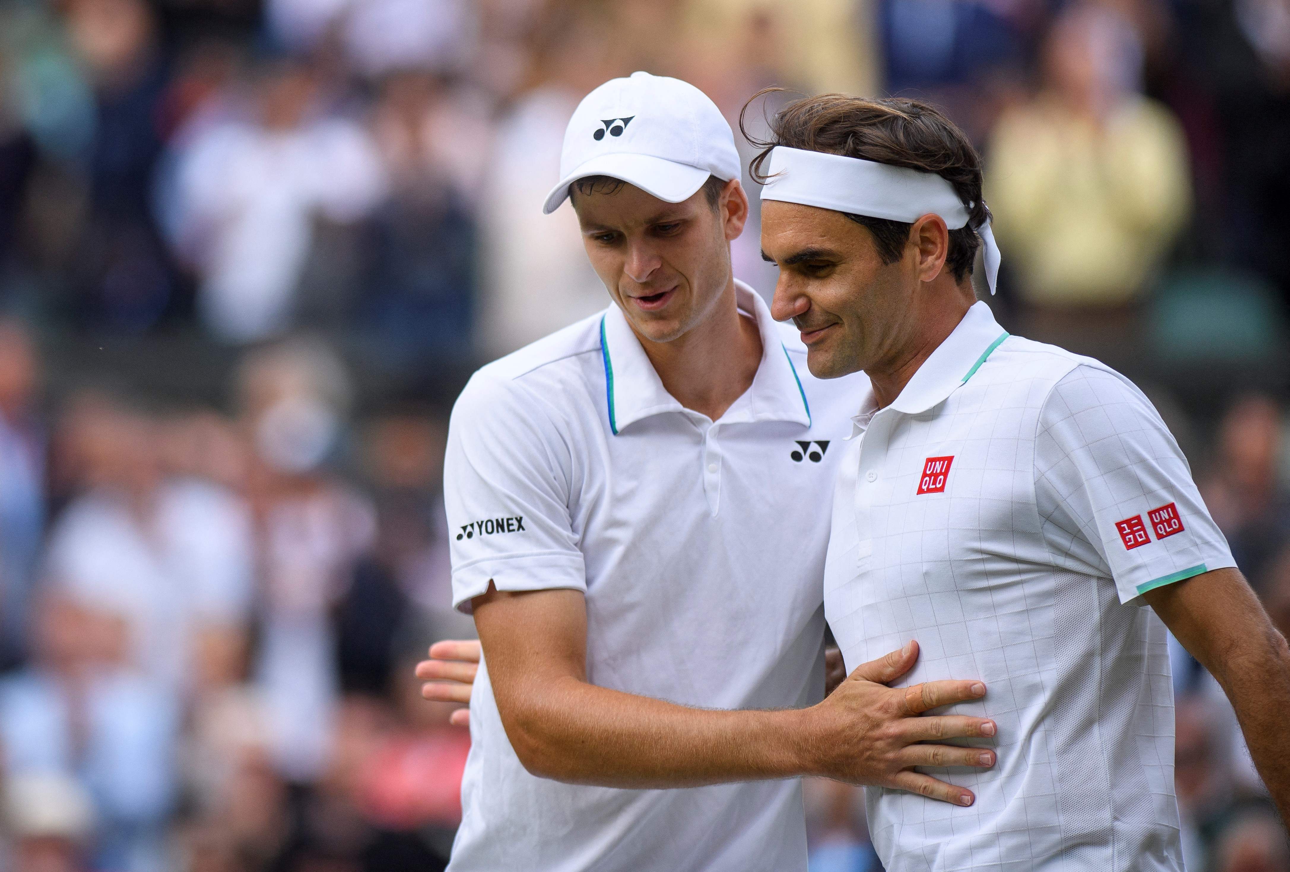 Petenis Swiss Roger Federer (kanan) menyelamati petenis Polandia Hubert Hurkacz selepas laga perempat final Wimbledon.