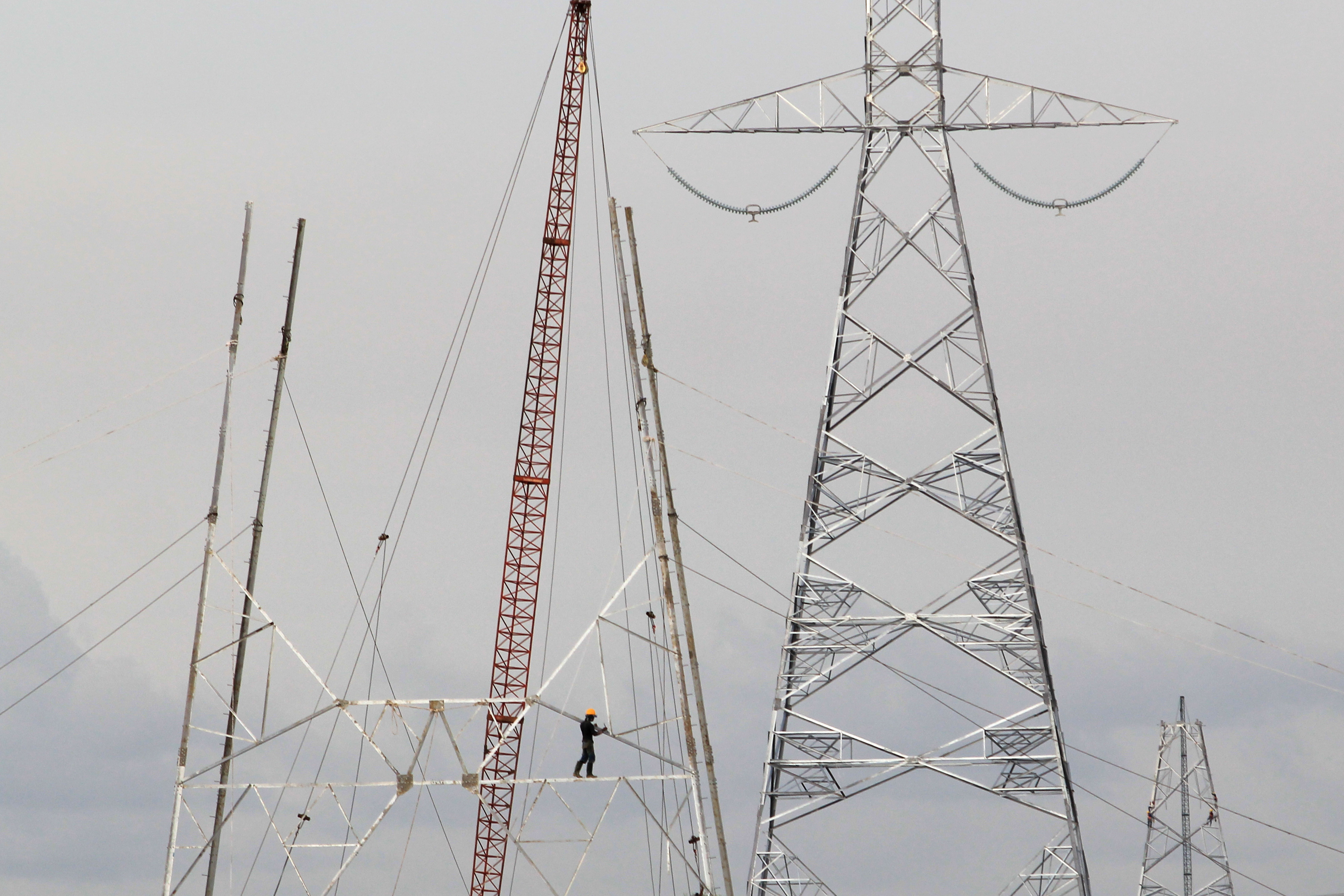 Pekerja melakukan proses pembangunan menara SUTET untuk sambungan PLTU.
