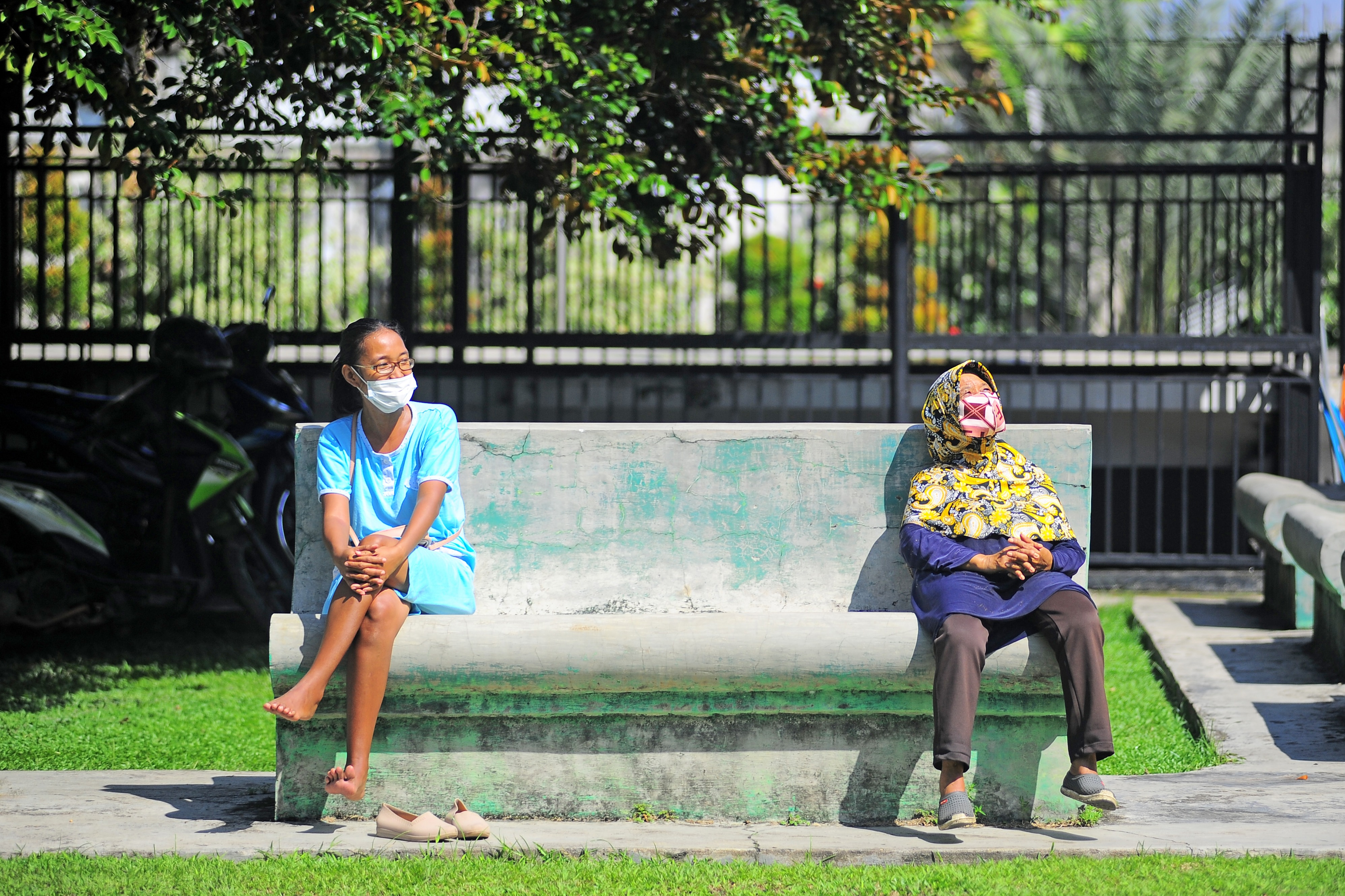 Dua warga berjemur di ruang terbuka Telanaipura, Jambi.
